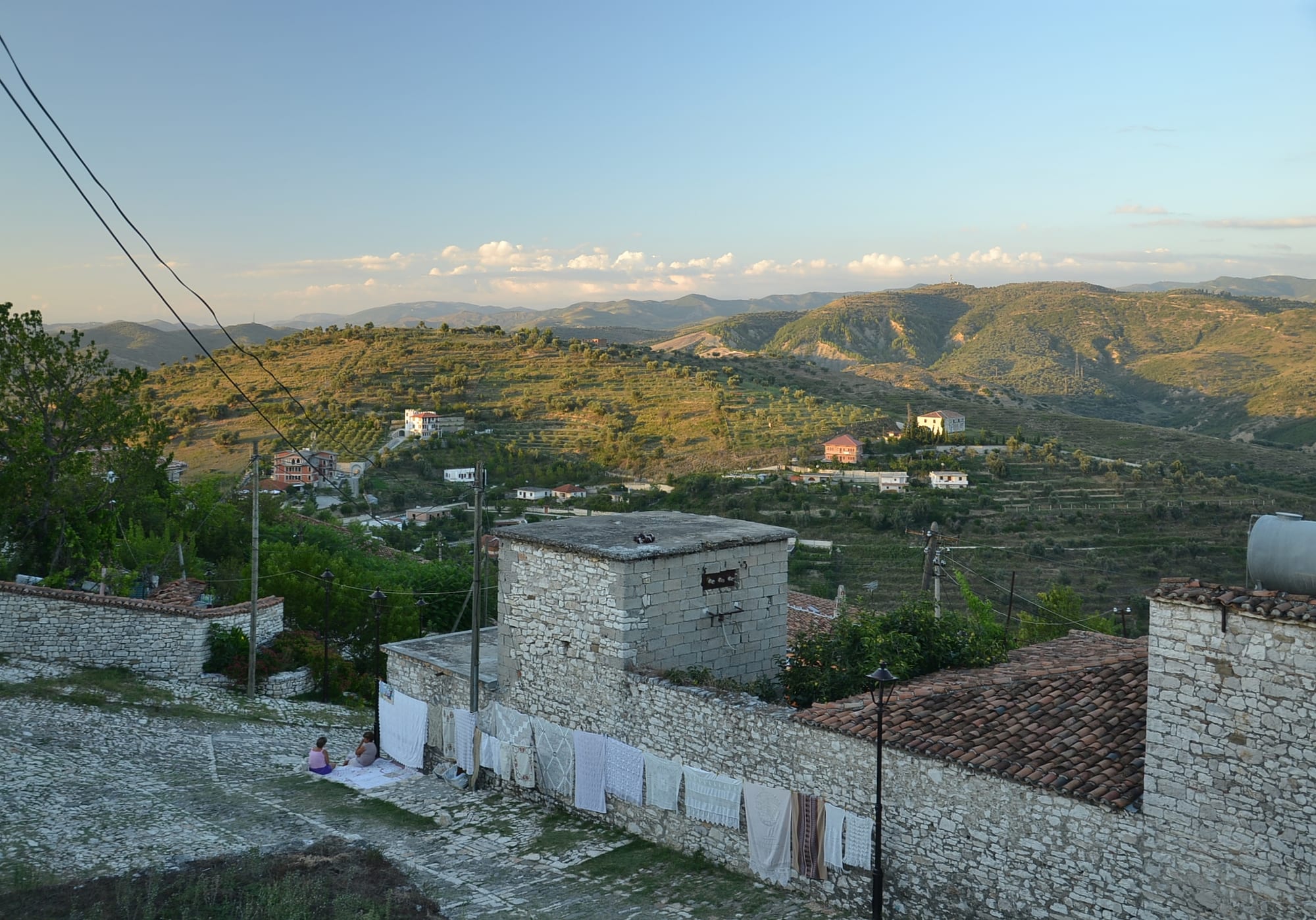 Tiers of white Ottoman houses with large windows rising up a hillside above a river