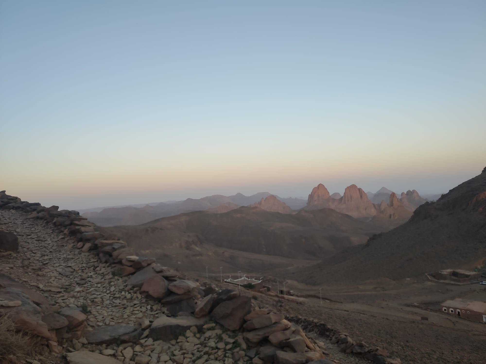 Jagged dark volcanic peaks catching the light of sunrise across a high desert plateau