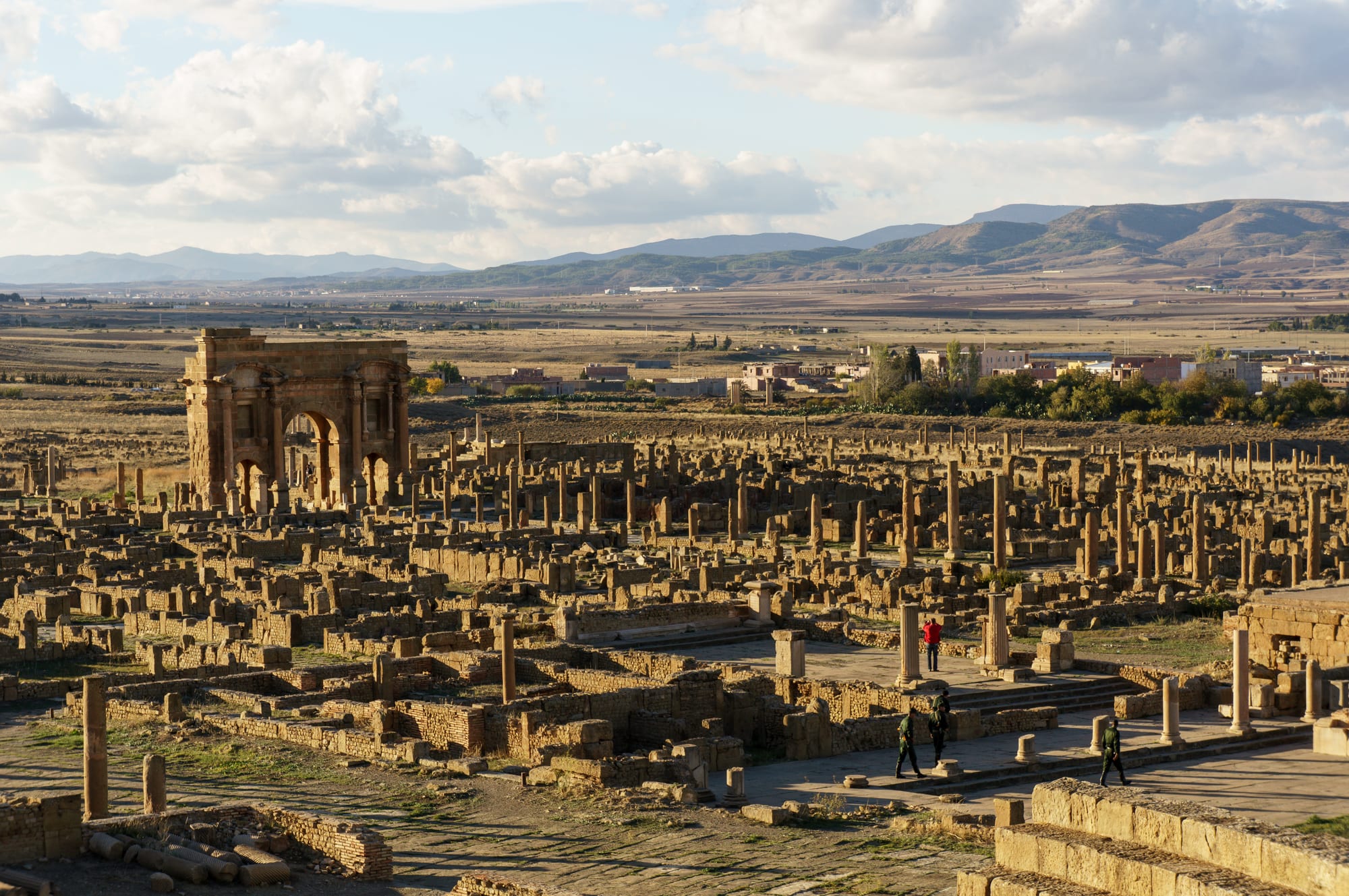 A grid of paved Roman streets, columns and a triumphal arch on a bare plain