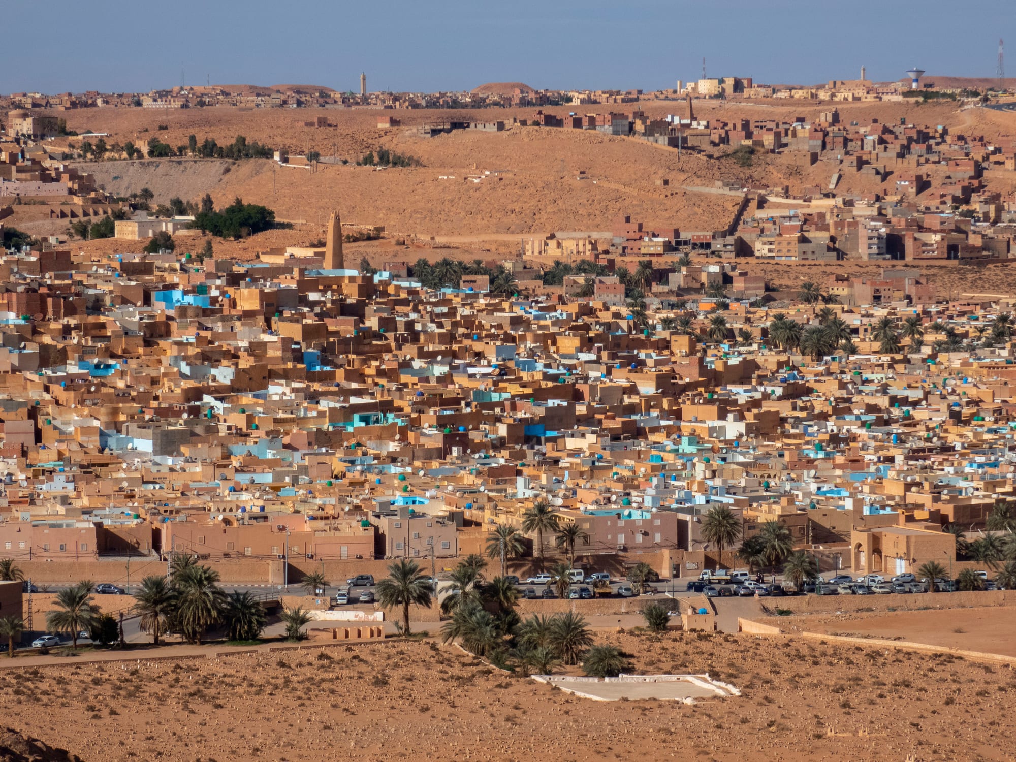 A compact desert town of pale cubic houses rising to a minaret on a low hill