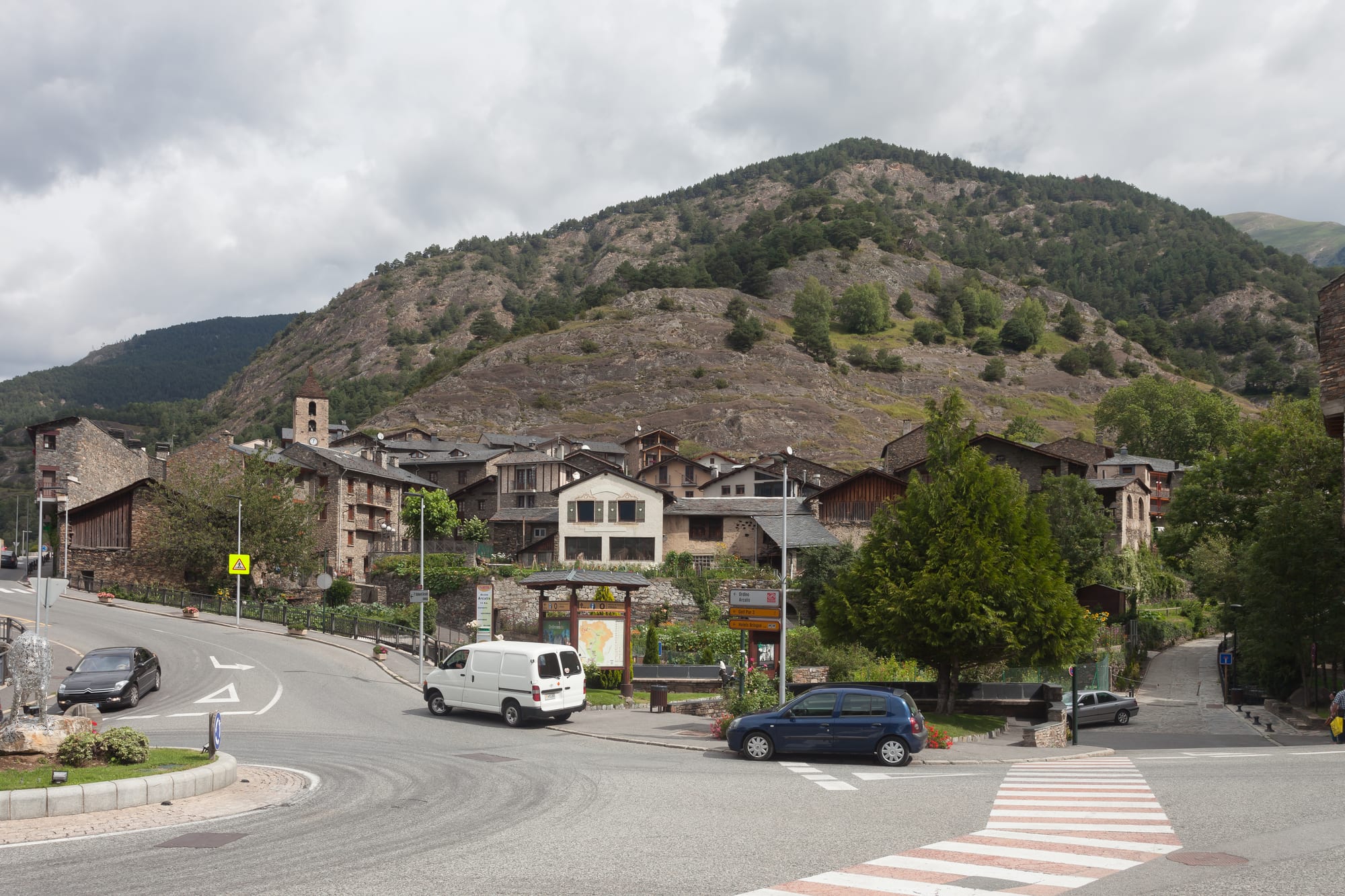 A compact stone mountain village with slate roofs and a church tower