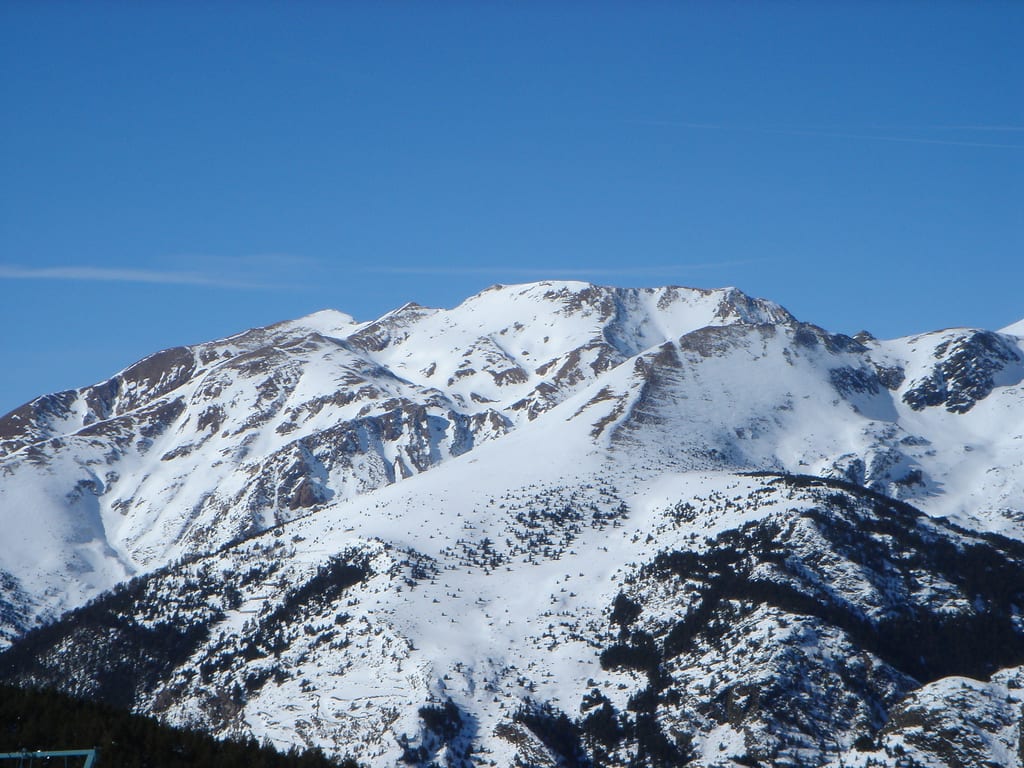 Snow-covered mountain peaks of the Grandvalira ski area under a clear blue sky
