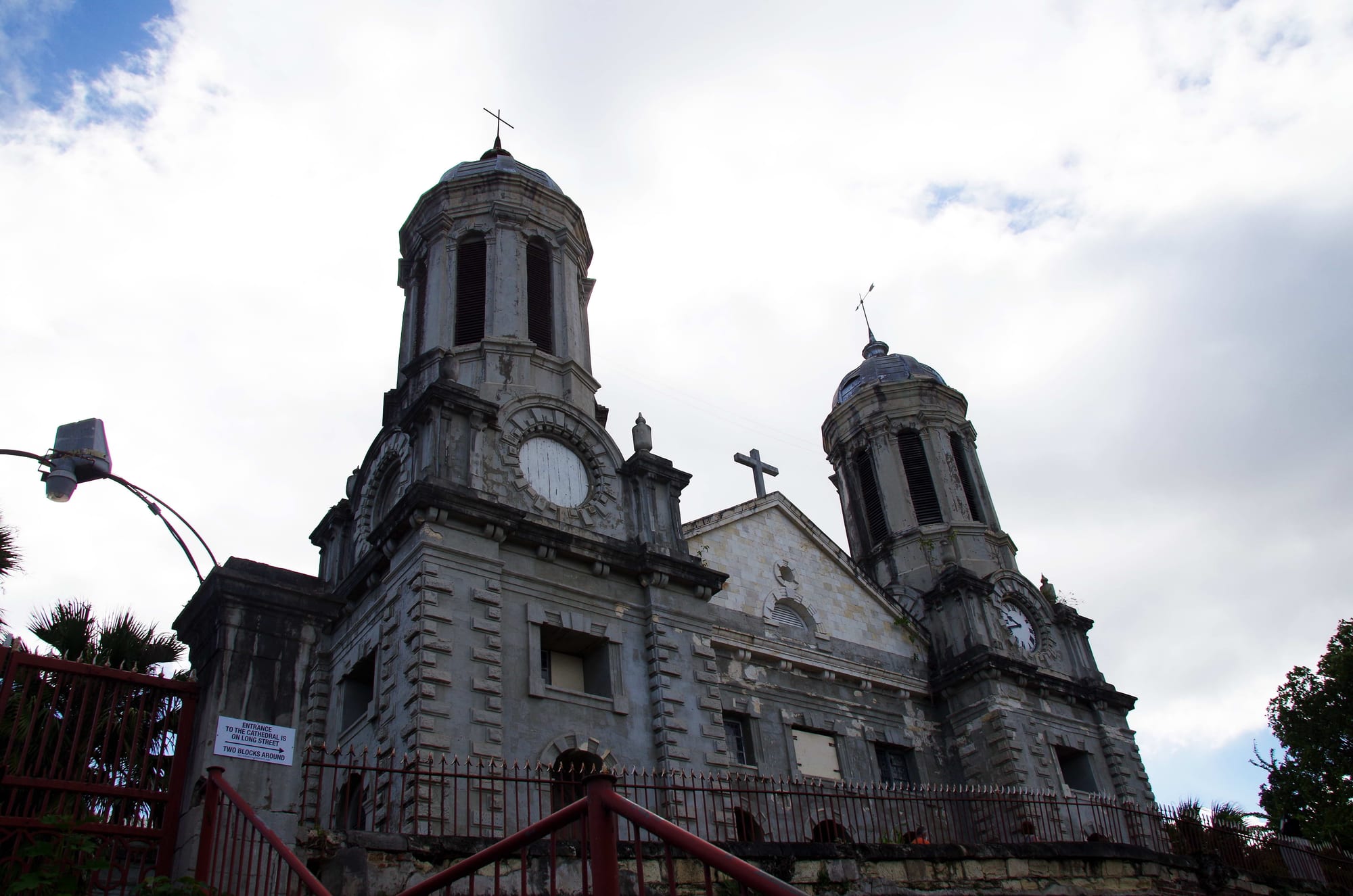 A large pale stone cathedral with twin baroque towers above a small town