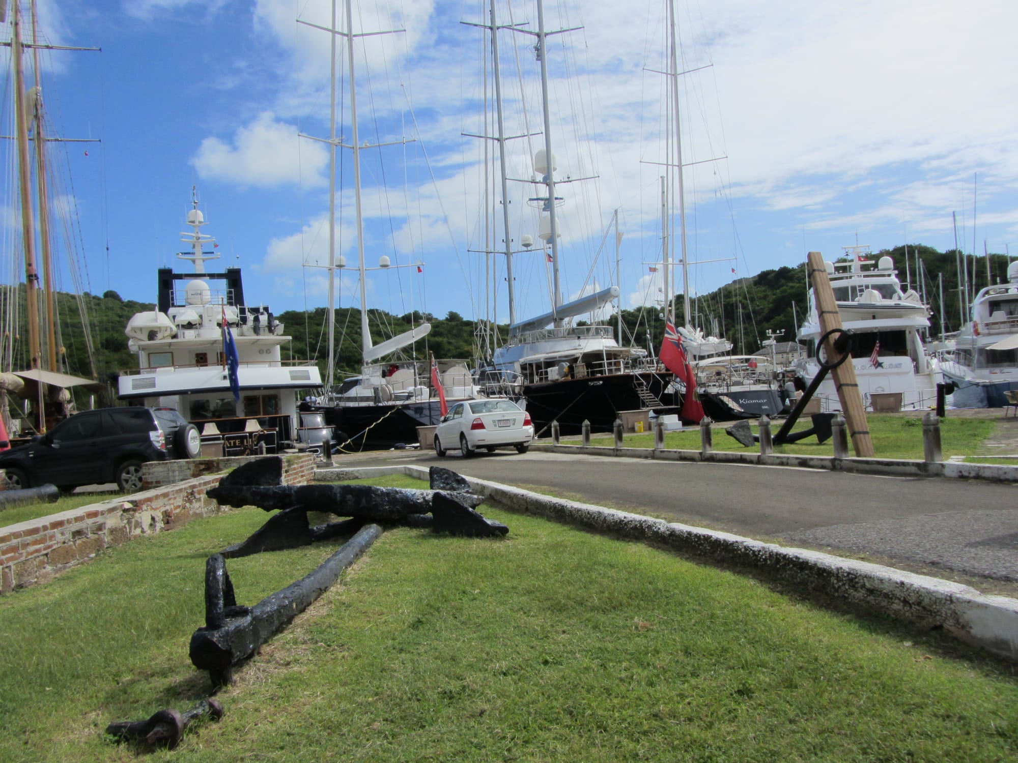 A calm harbour with yachts, ringed by old stone Georgian buildings and green hills