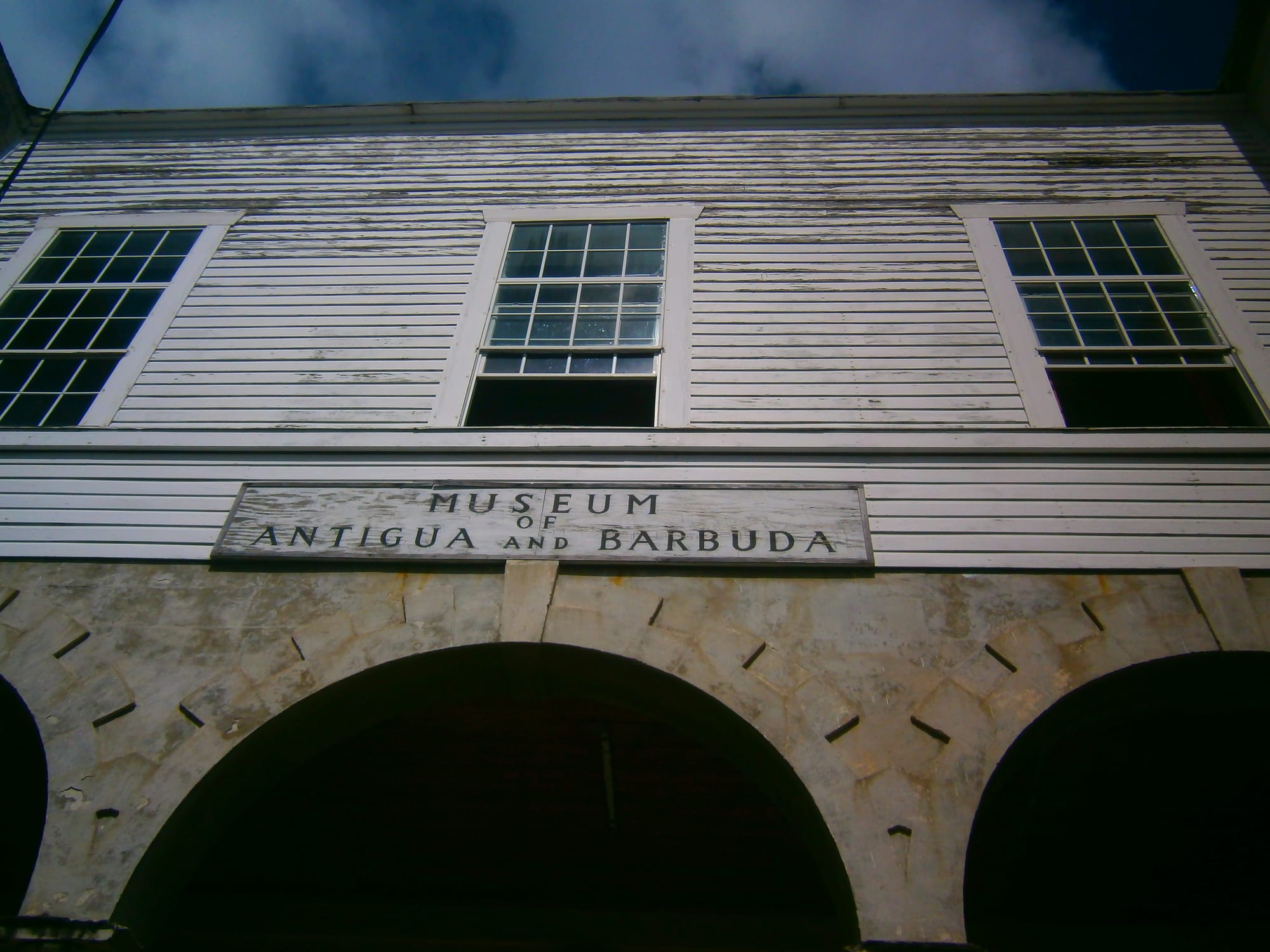 A two-storey colonial stone building with arched arcades, formerly a courthouse, in a town