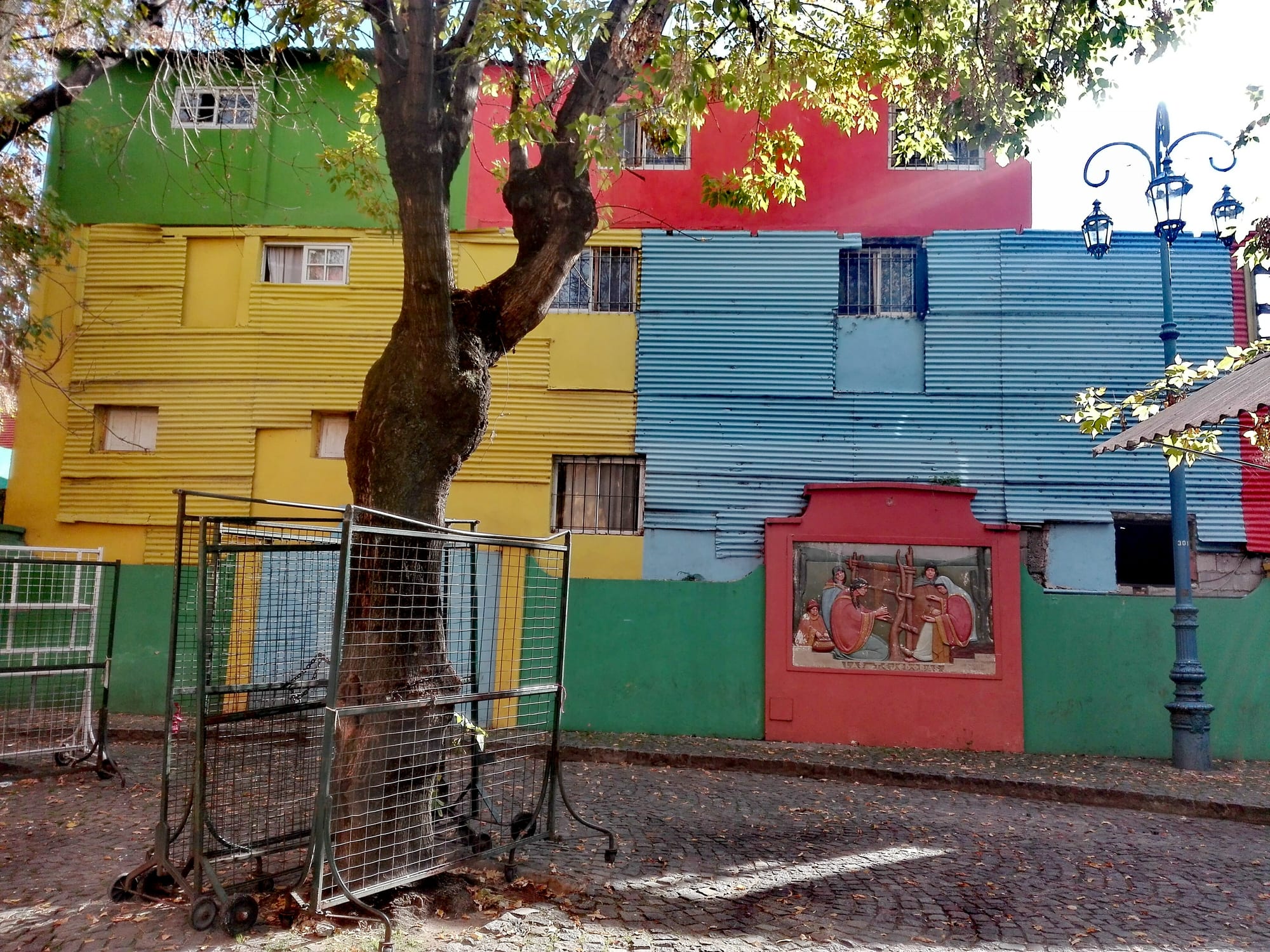A tin-sheeted house painted in blocks of bright red, blue, yellow and green