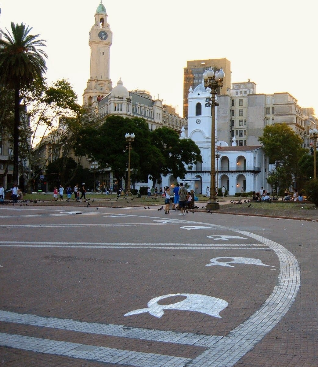 White headscarves painted onto grey paving stones in a circle around a monument