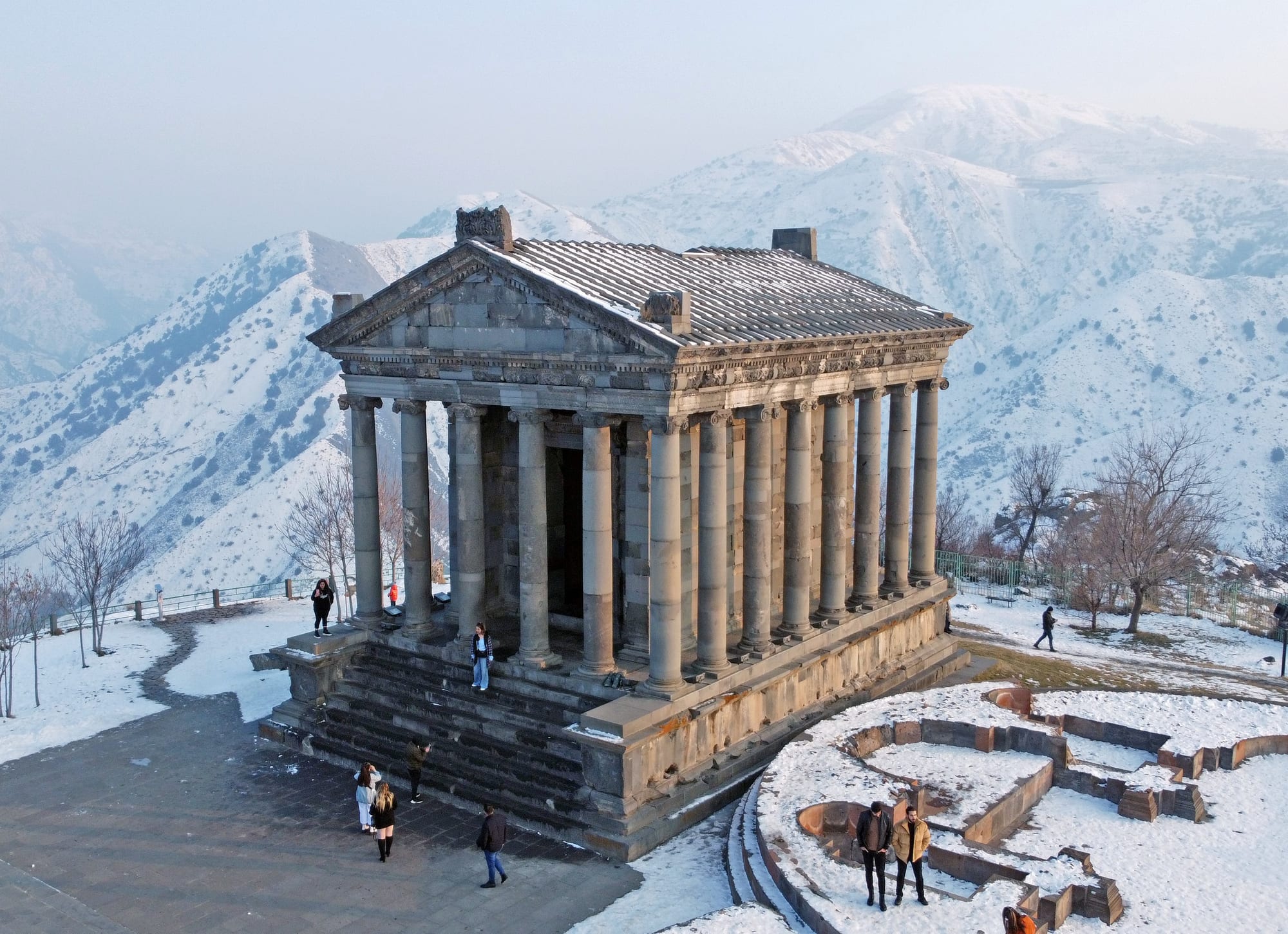 A small Greco-Roman colonnaded temple on the edge of a deep canyon