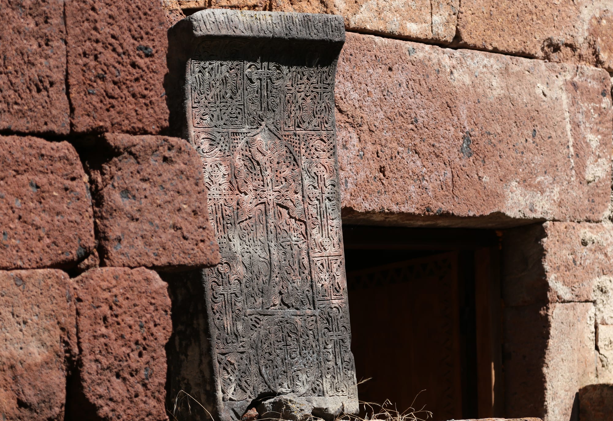 An intricately carved stone slab bearing a cross wreathed in interlacing patterns