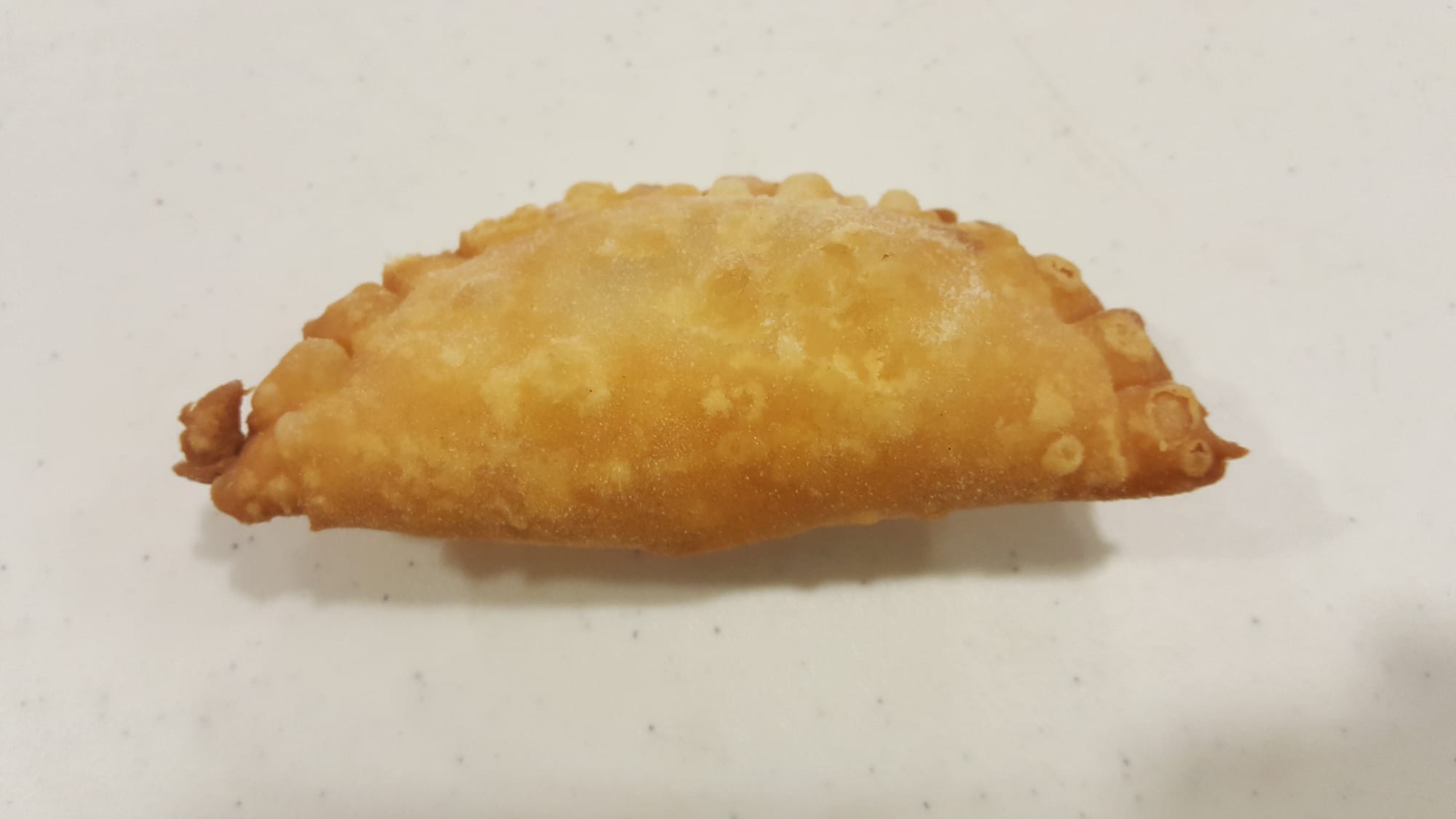 A single golden, crimped-edge fried pastry turnover on a plain background