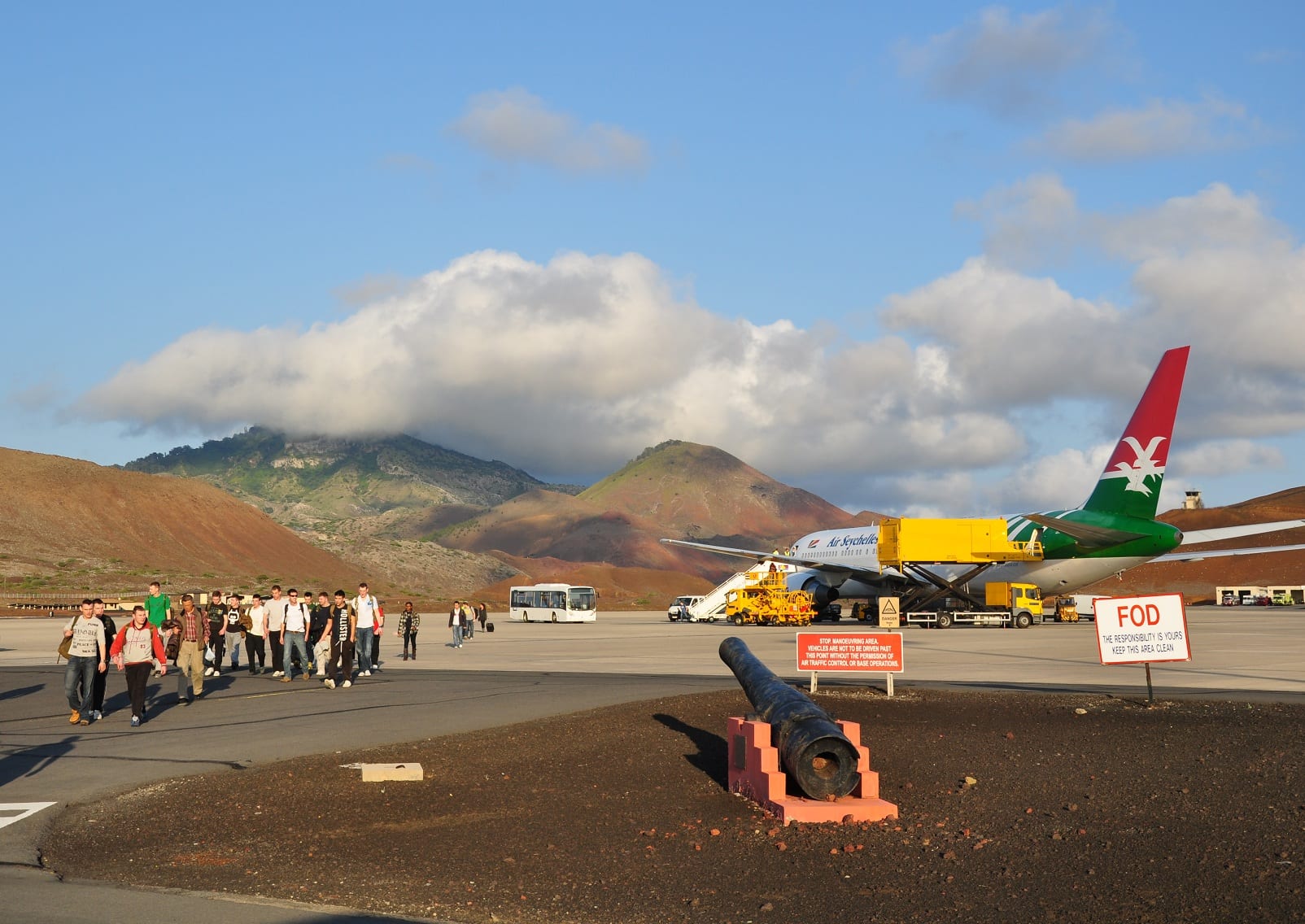 A long airstrip on a flat lava plain with low hills behind