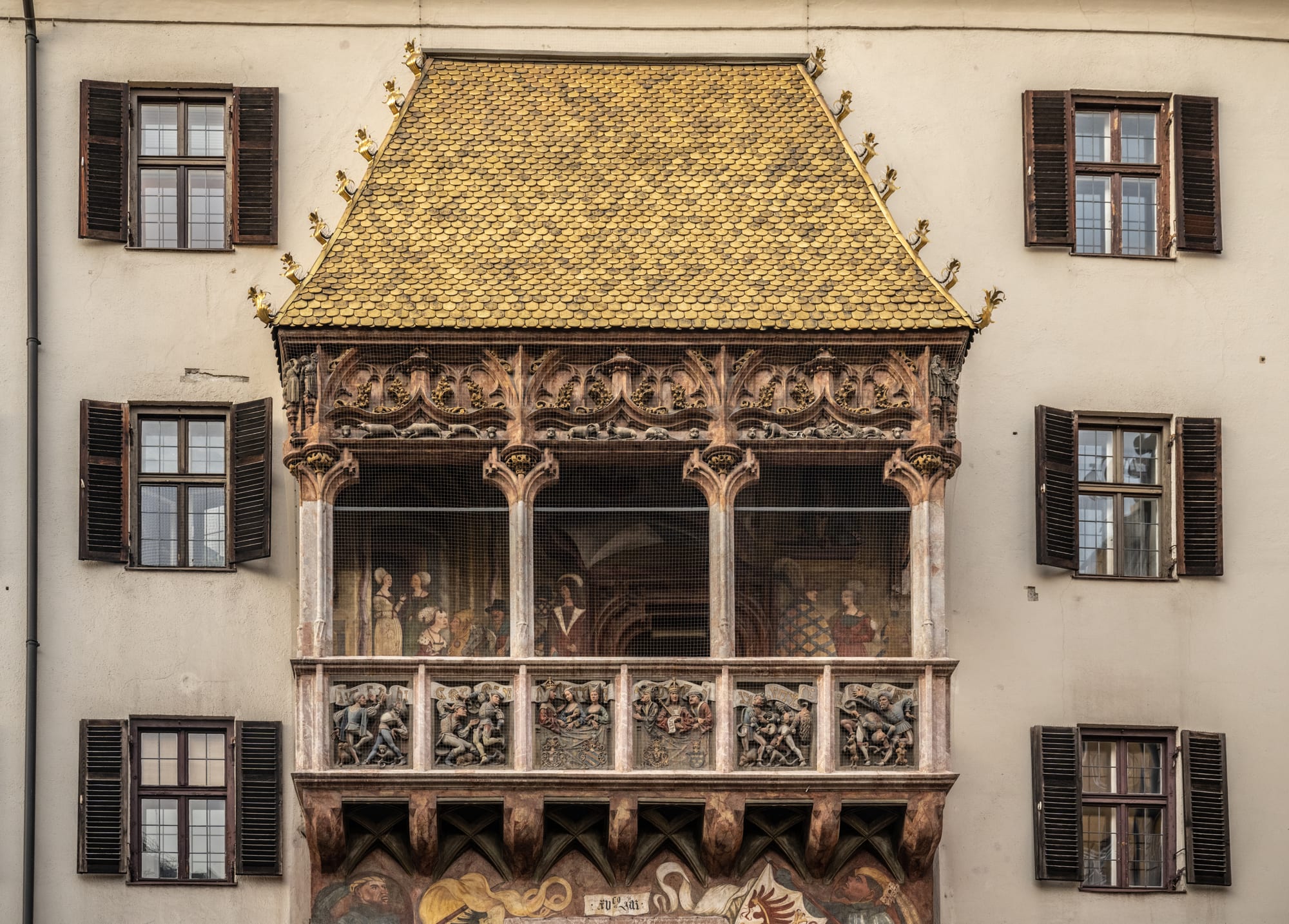 A late-Gothic oriel balcony roofed with hundreds of gilded copper tiles above an old-town street