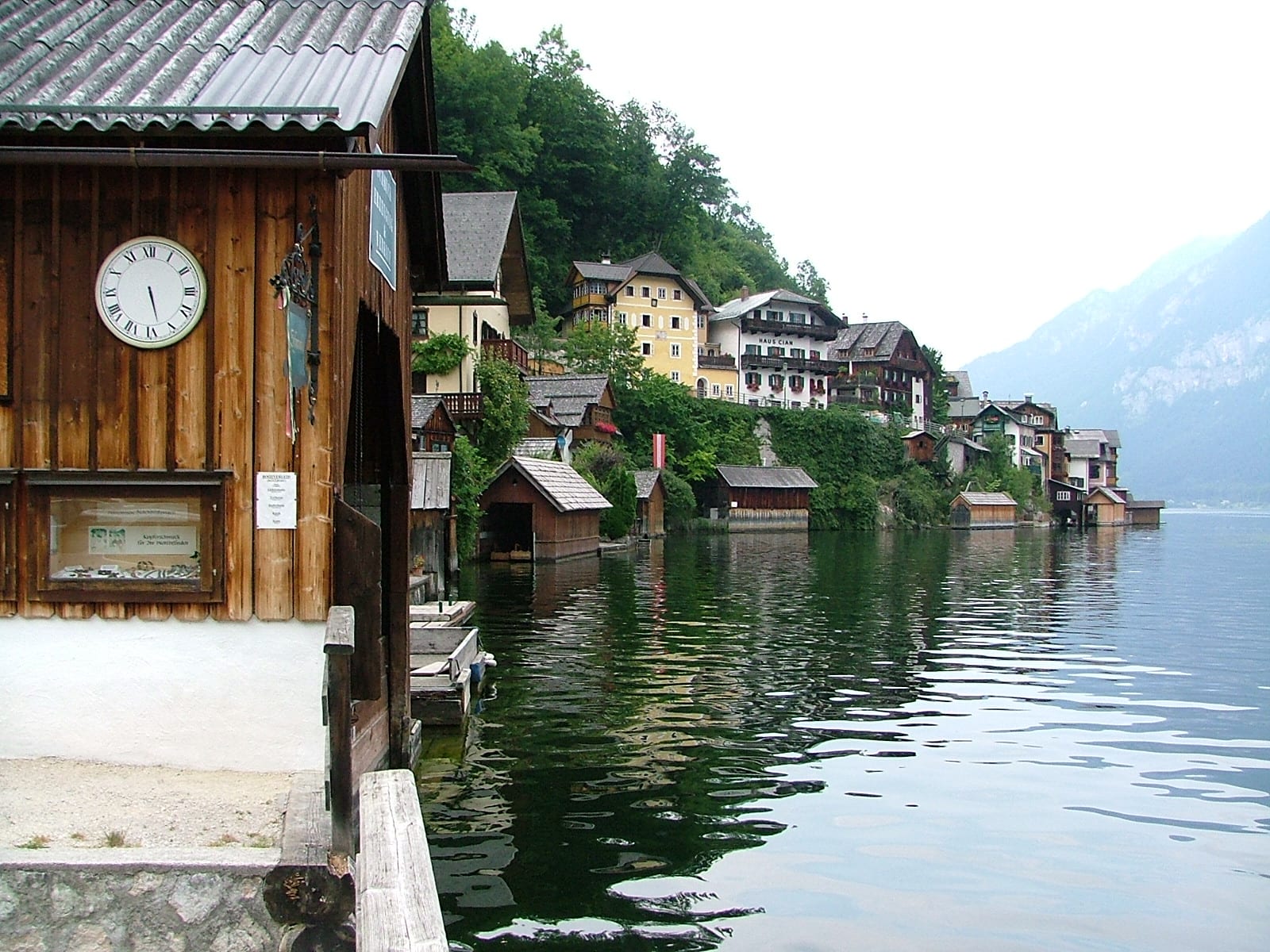 Pastel lakeside houses with flower boxes, mountains rising directly behind