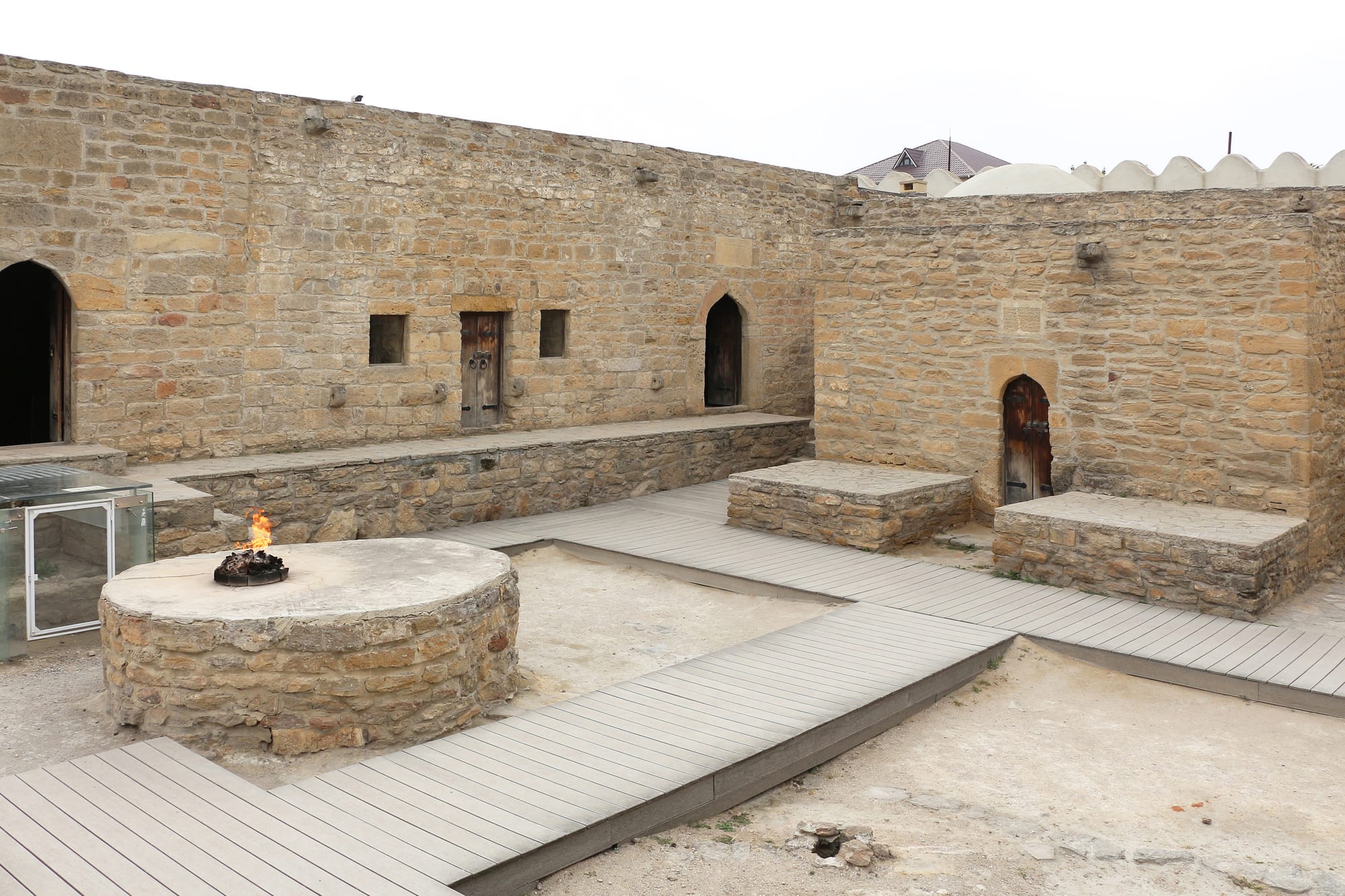 A pentagonal stone courtyard with a domed altar in the centre, flames burning in it