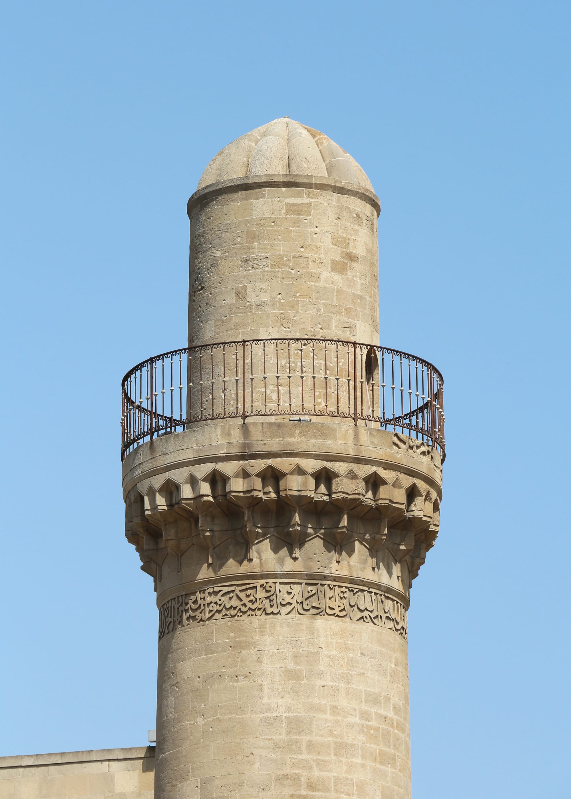 A domed sandstone palace complex with carved portals on a terraced hillside