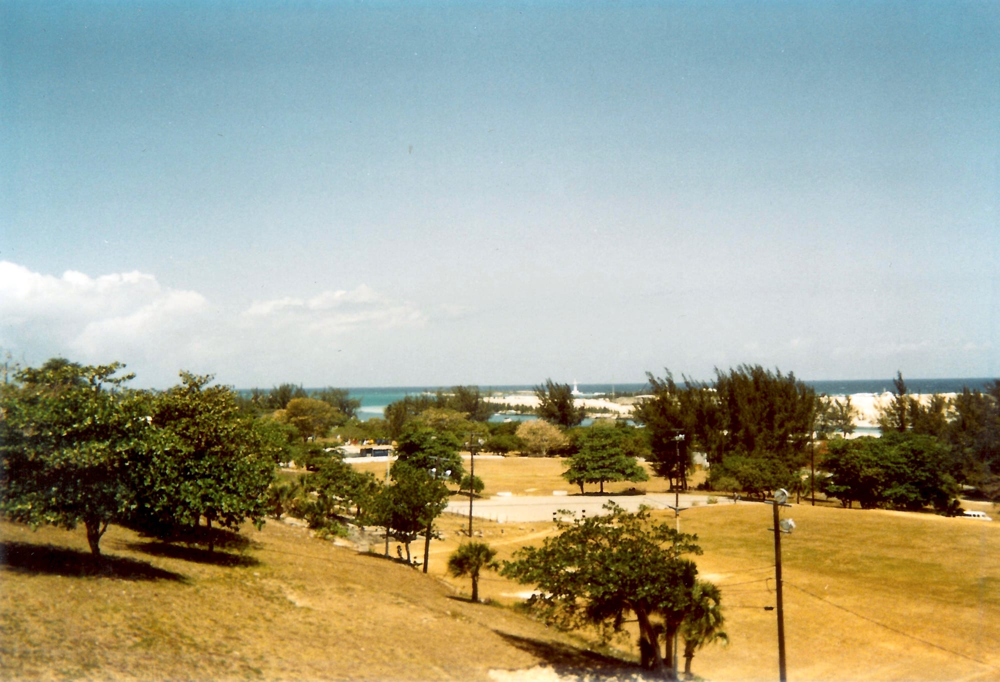 Thick stone ramparts and a dry moat of a hilltop fort overlooking a harbour and town