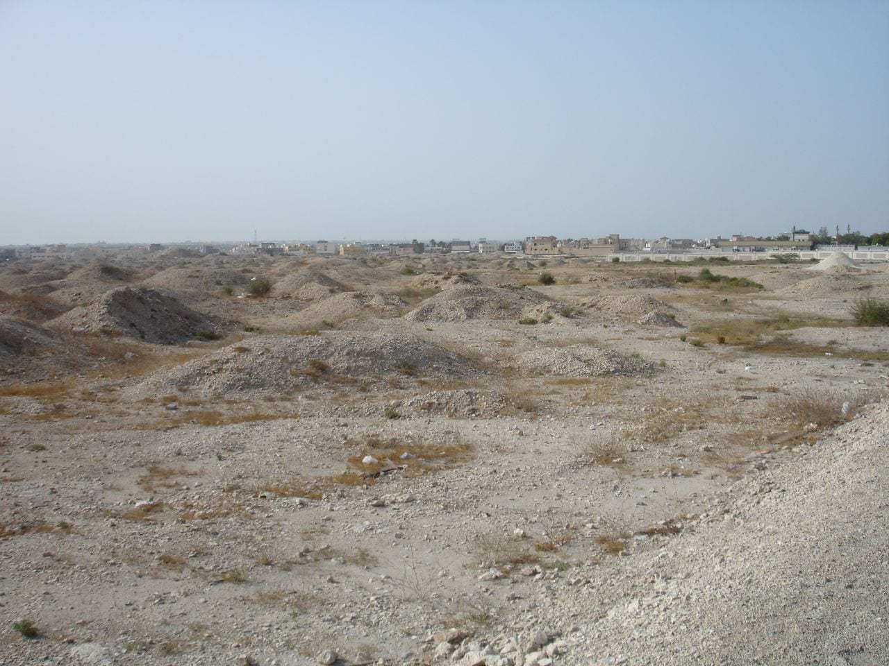 A field of low rounded earth mounds stretching to the horizon