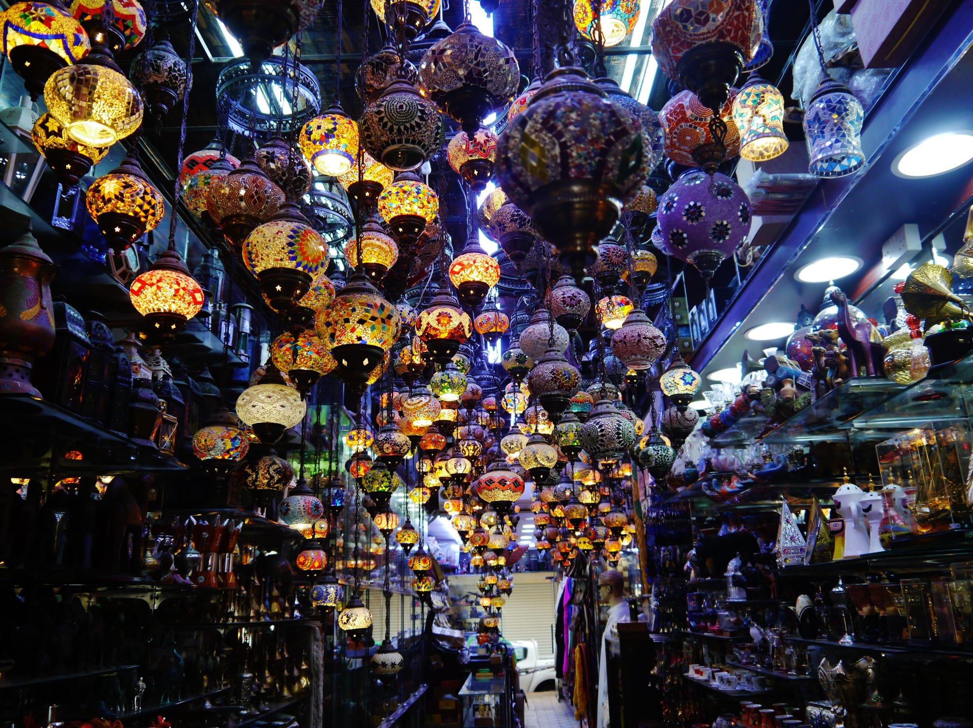 A busy covered market street with hanging goods and shopfronts