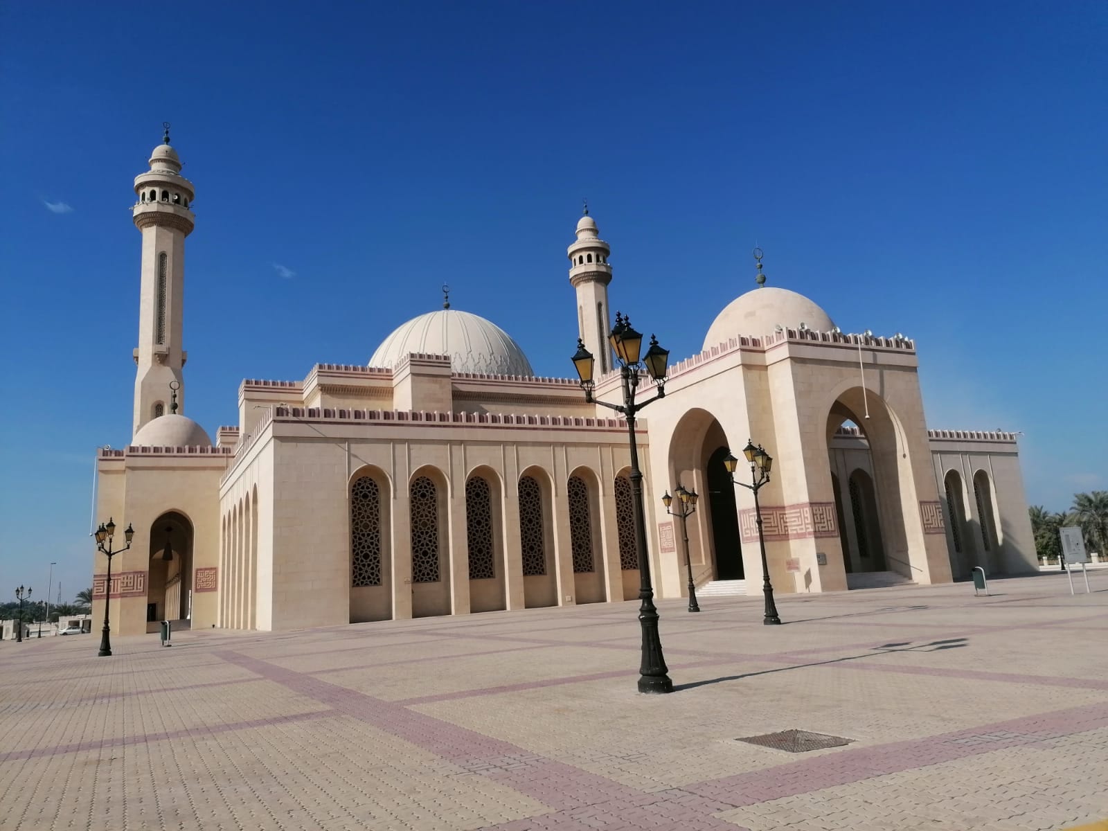 A large sand-coloured mosque with a huge dome and twin minarets