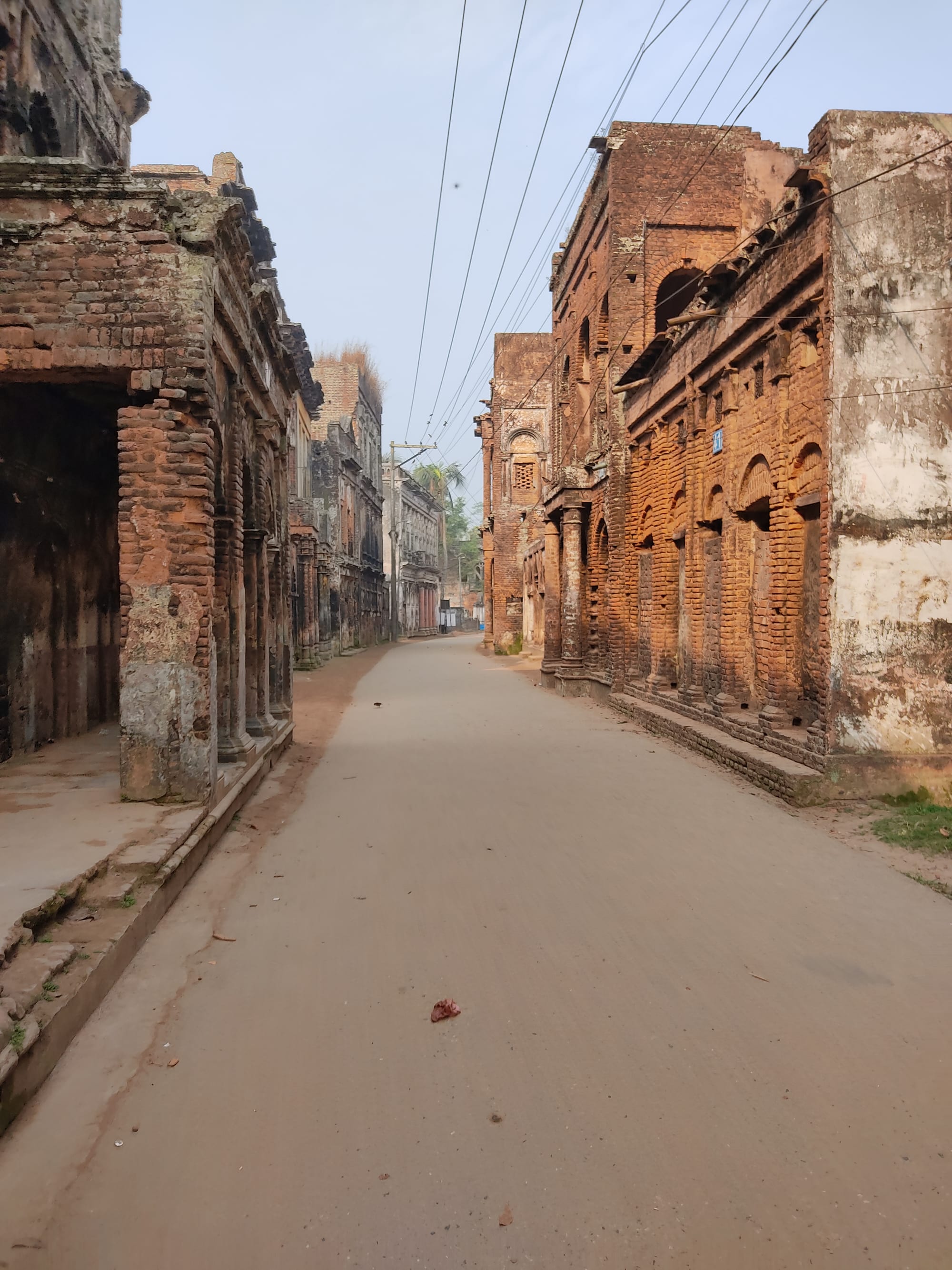 A street of decaying grand colonial-era townhouses with columns and shuttered windows
