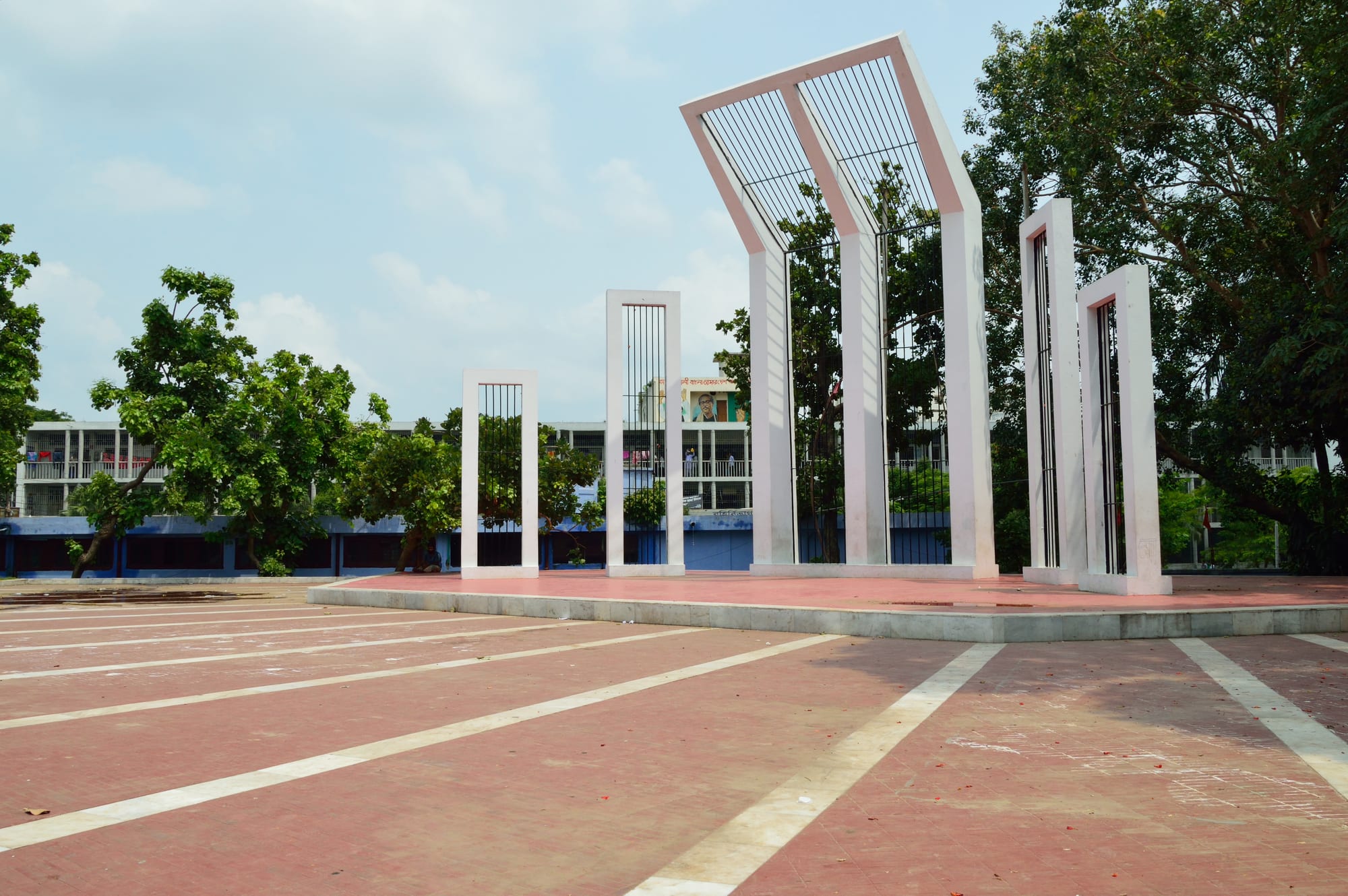 A monument of tall red-bordered white columns leaning together above a wide plaza