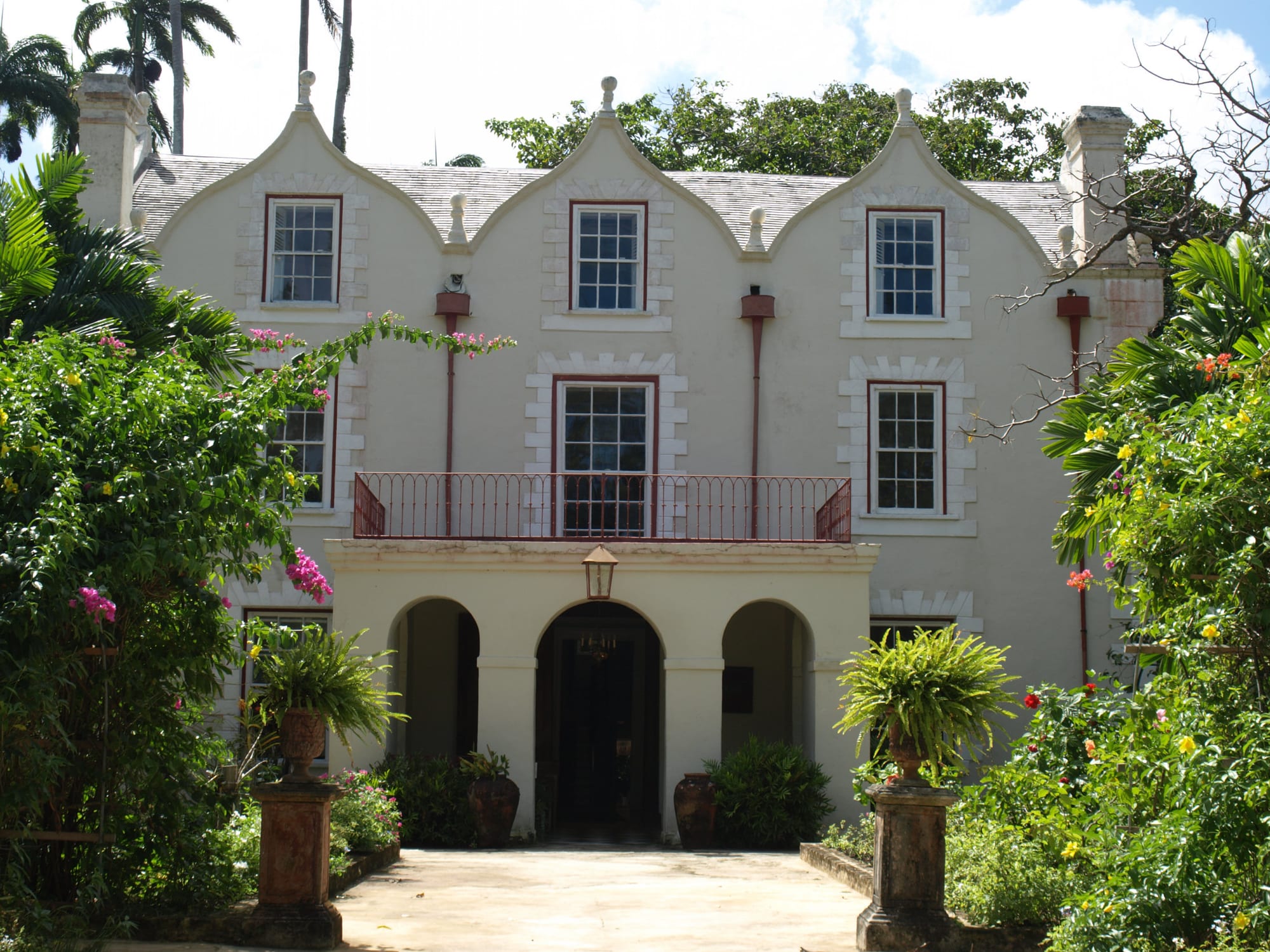 A three-storey Jacobean great house with curved gables and tall chimneys among mature trees