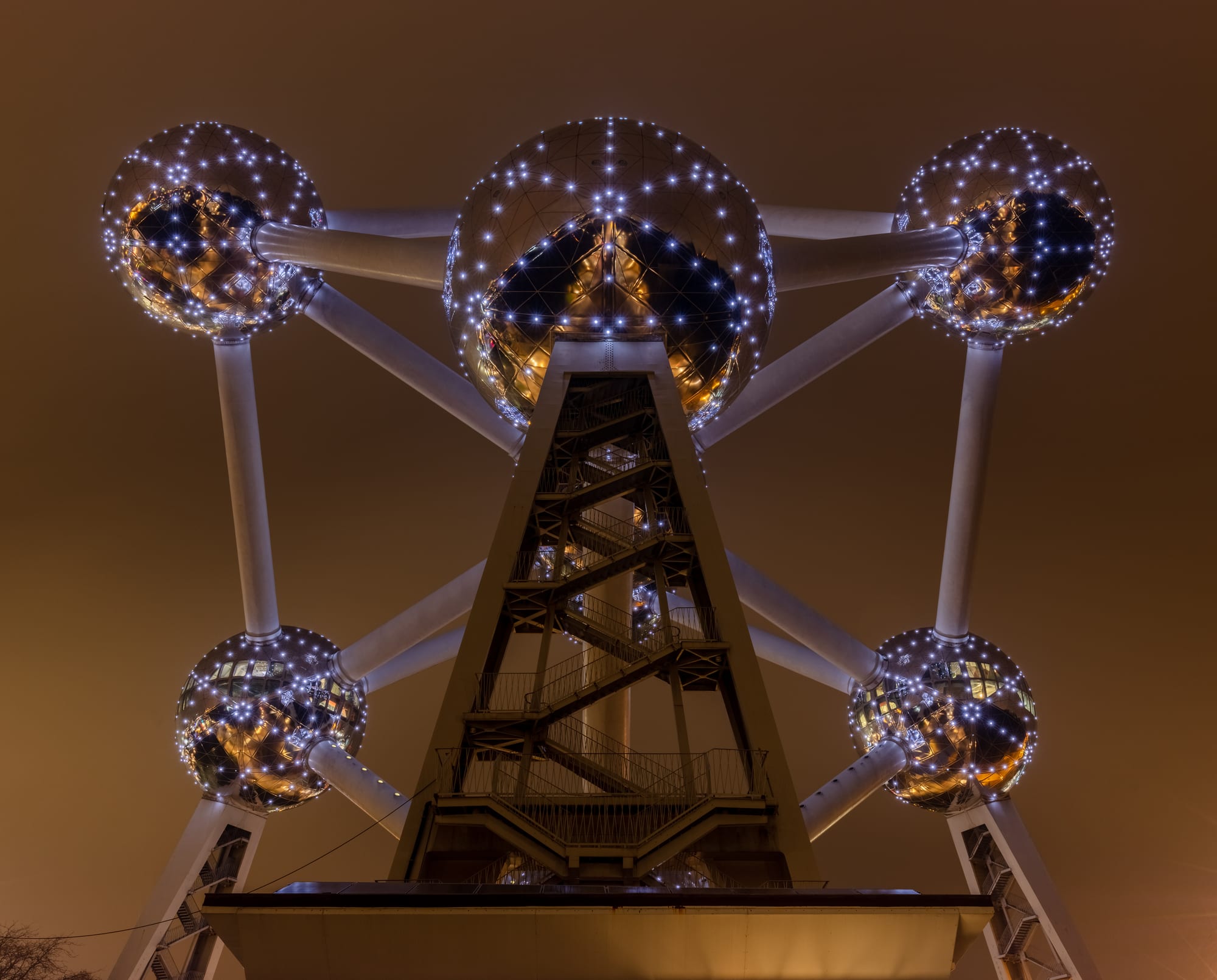 A giant silver model of a metal crystal — nine spheres joined by tubes — on a lawn