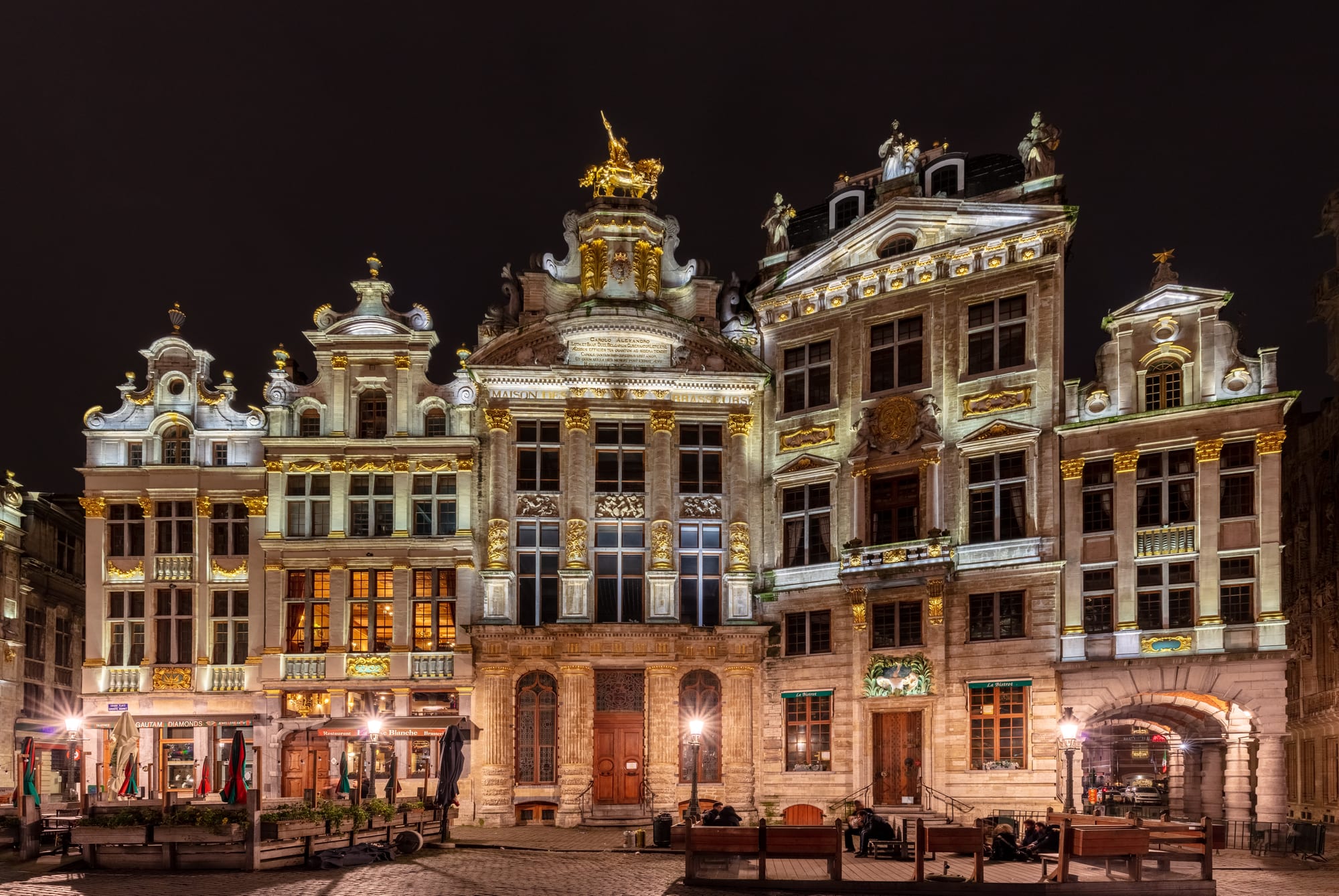 A square enclosed by ornate gilded guild houses with steep gables
