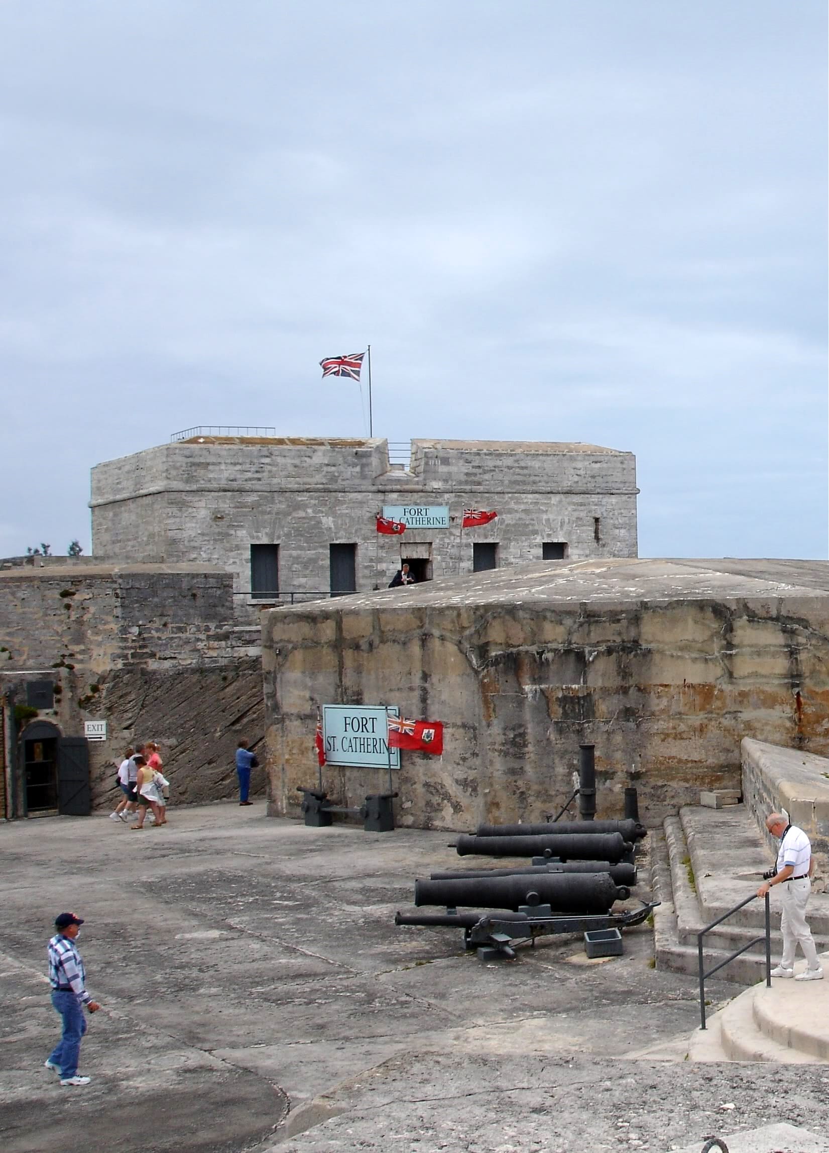 A restored white coastal fort with ramparts and cannon above a sandy beach