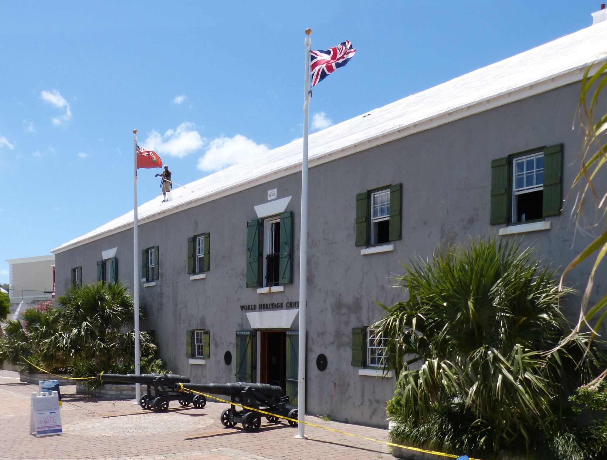 Pastel-painted colonial buildings with white stepped roofs around a small harbour and town square