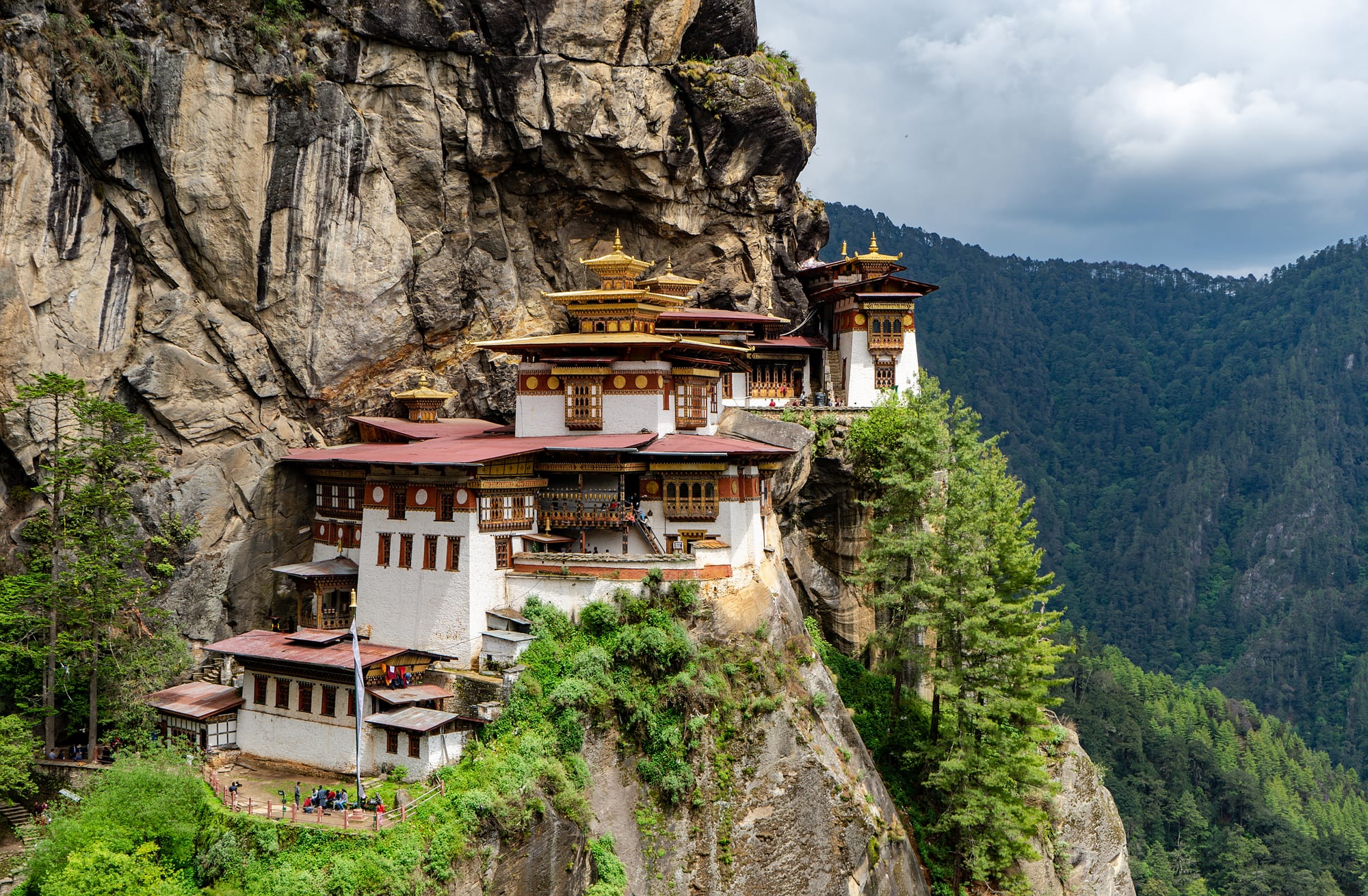 The white and gold monastery buildings of Tiger's Nest seen close up against the rock face