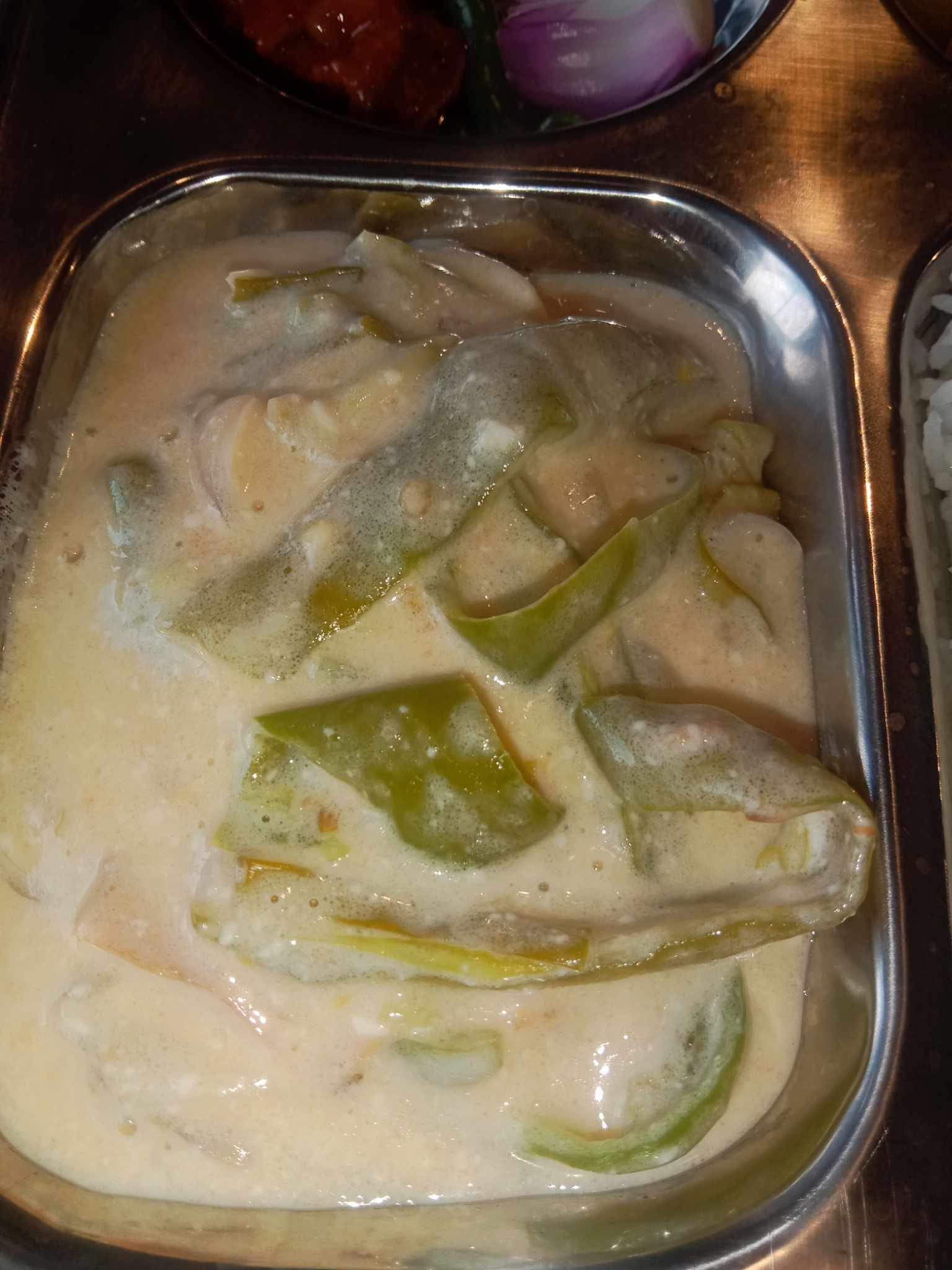 A bowl of green chillies in a thick, melted cheese sauce