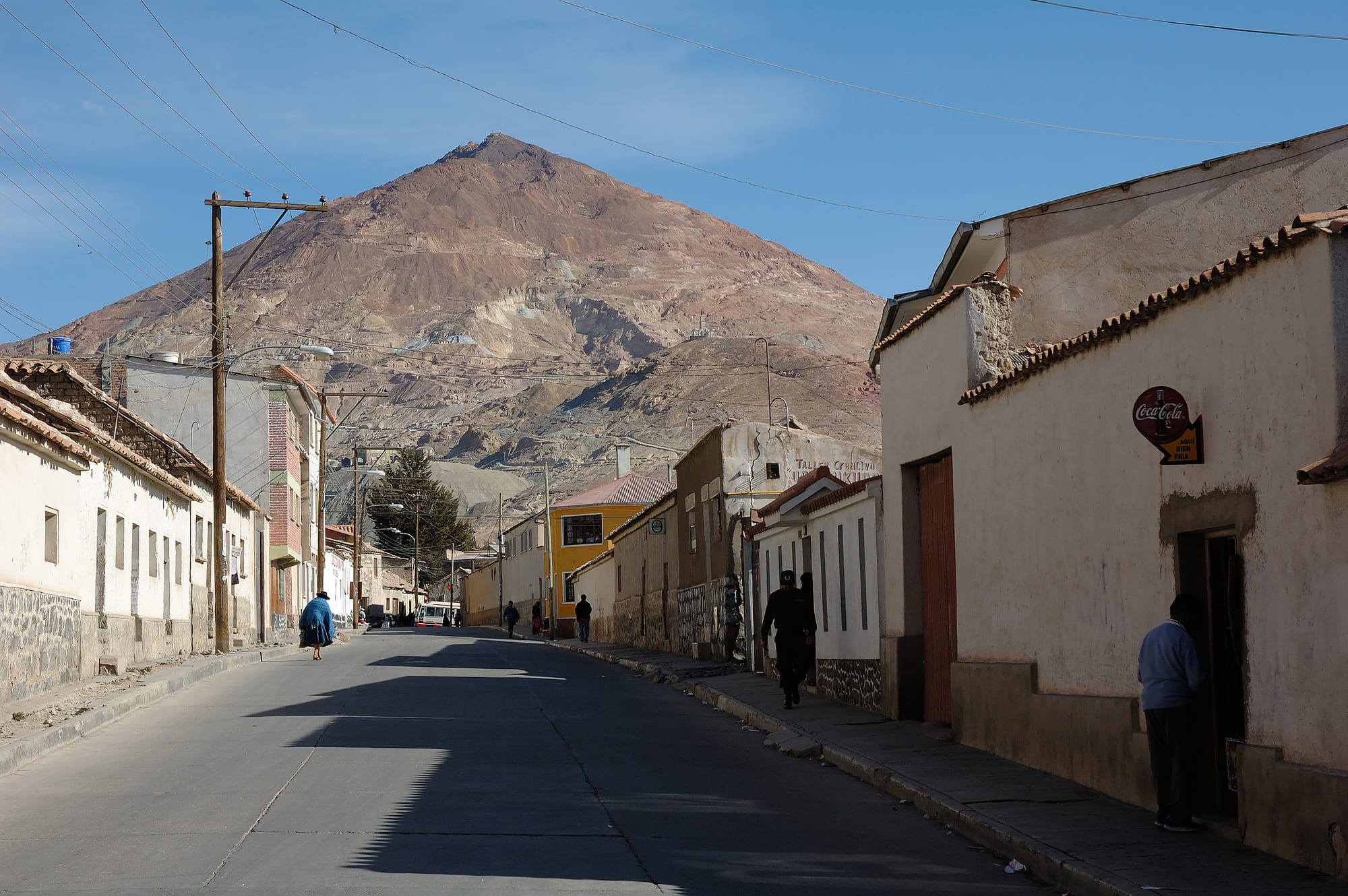 A conical red mountain rising behind a city of colonial churches and tiled roofs