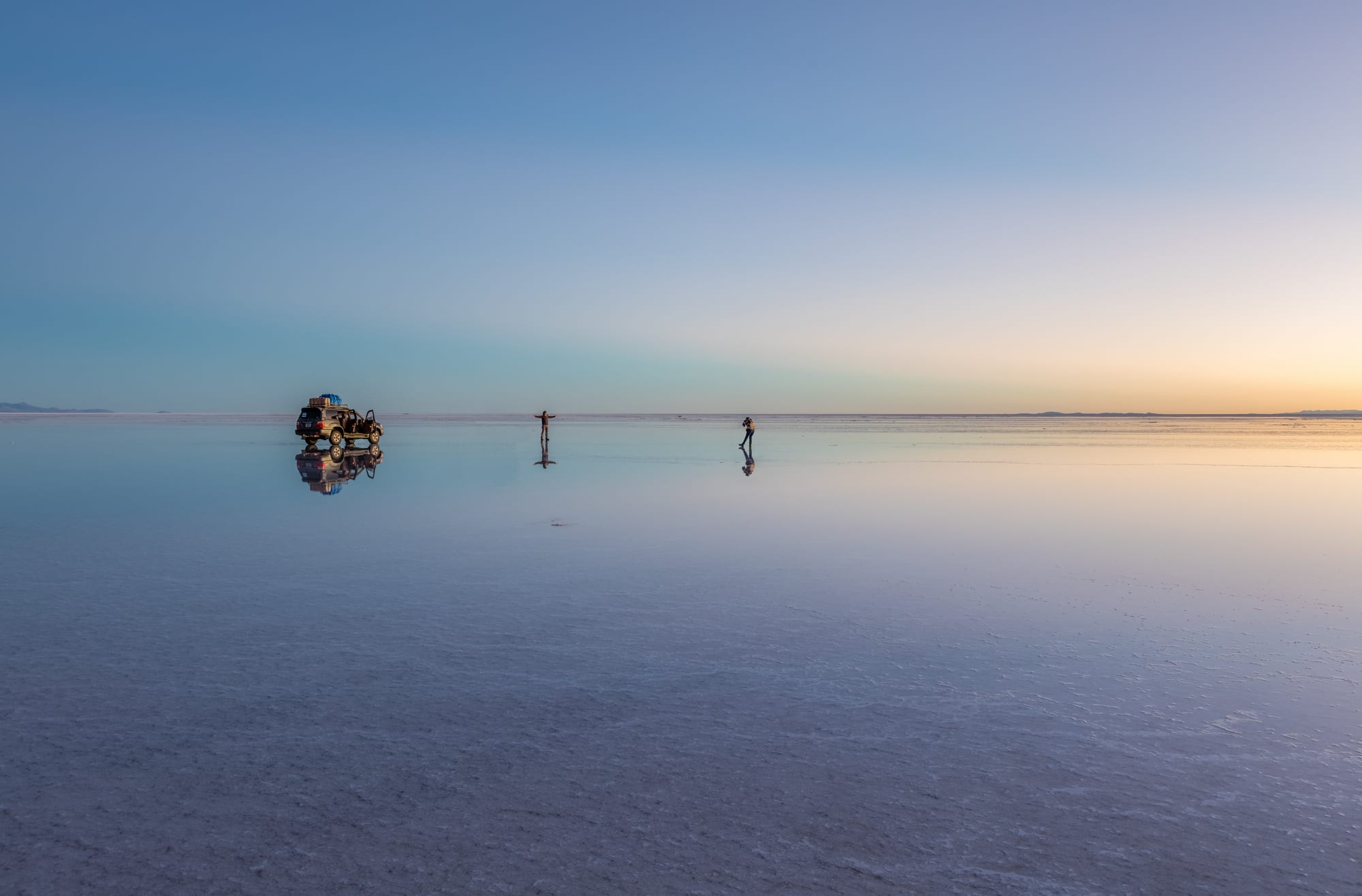 An endless flat white plain of hexagonal salt crust under a huge blue sky