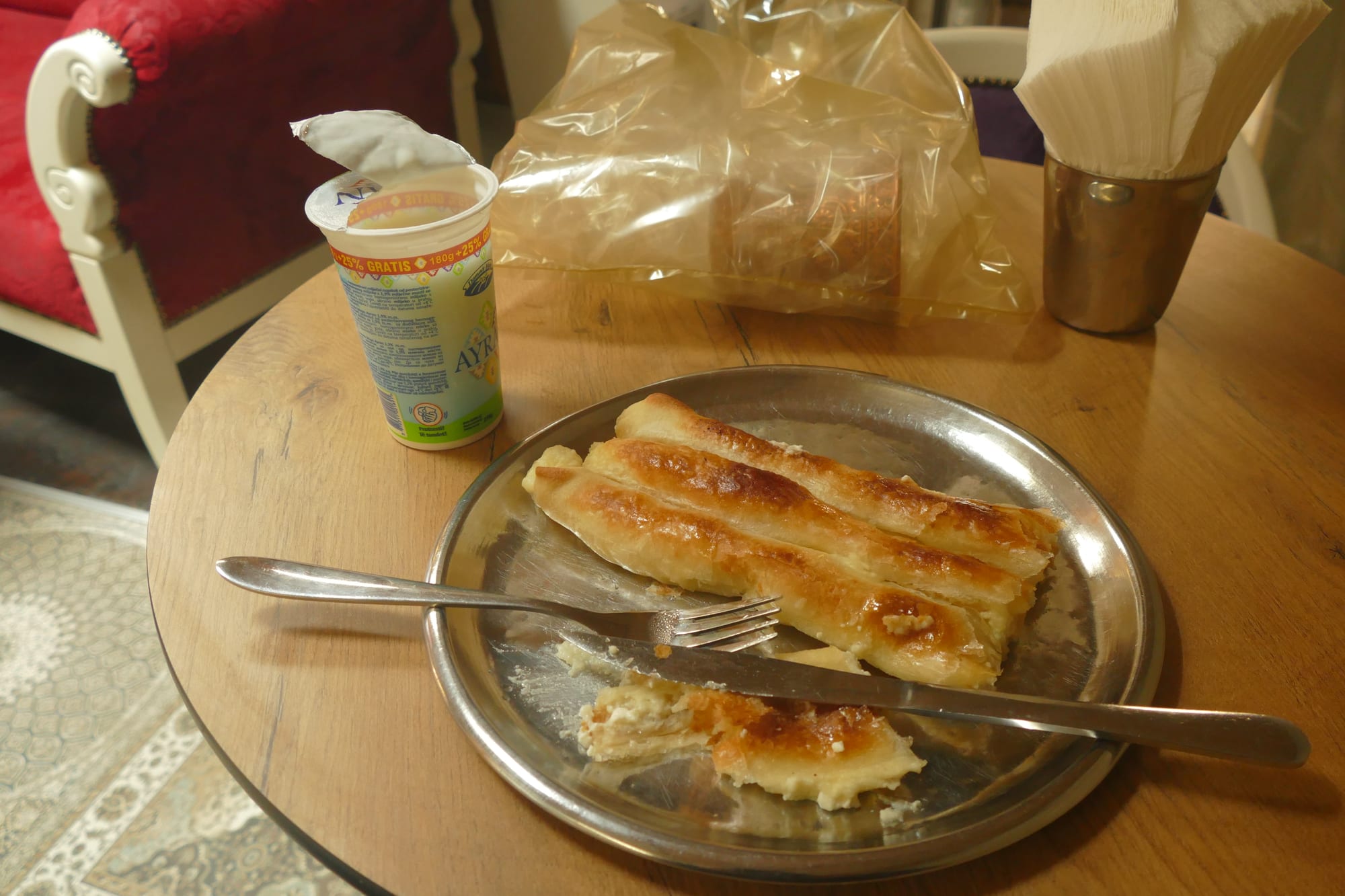A coiled spiral of golden filo pastry pie, cut to show a meat filling inside