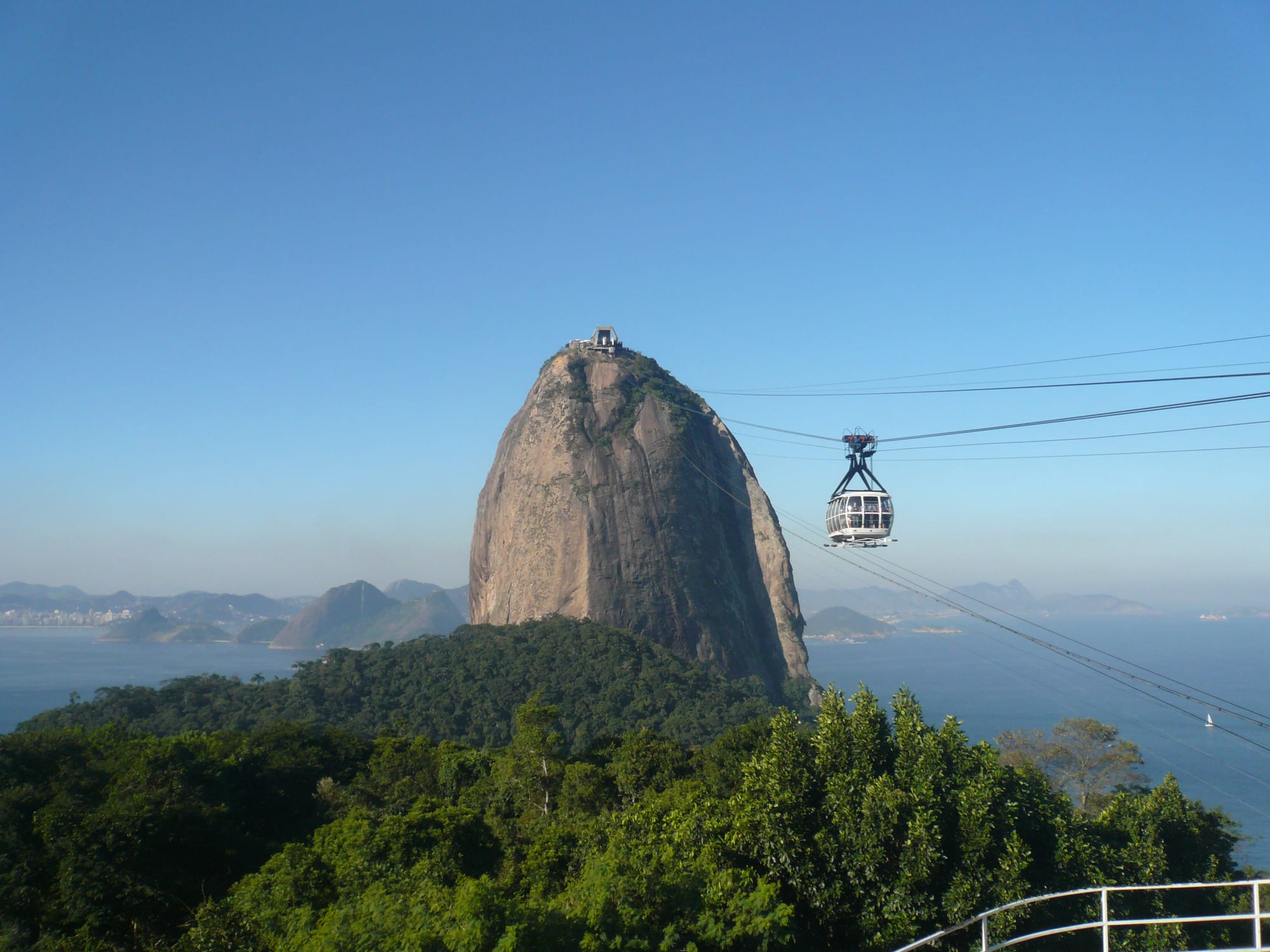 A rounded granite peak rising from the sea at the mouth of a bay, city and beaches around it