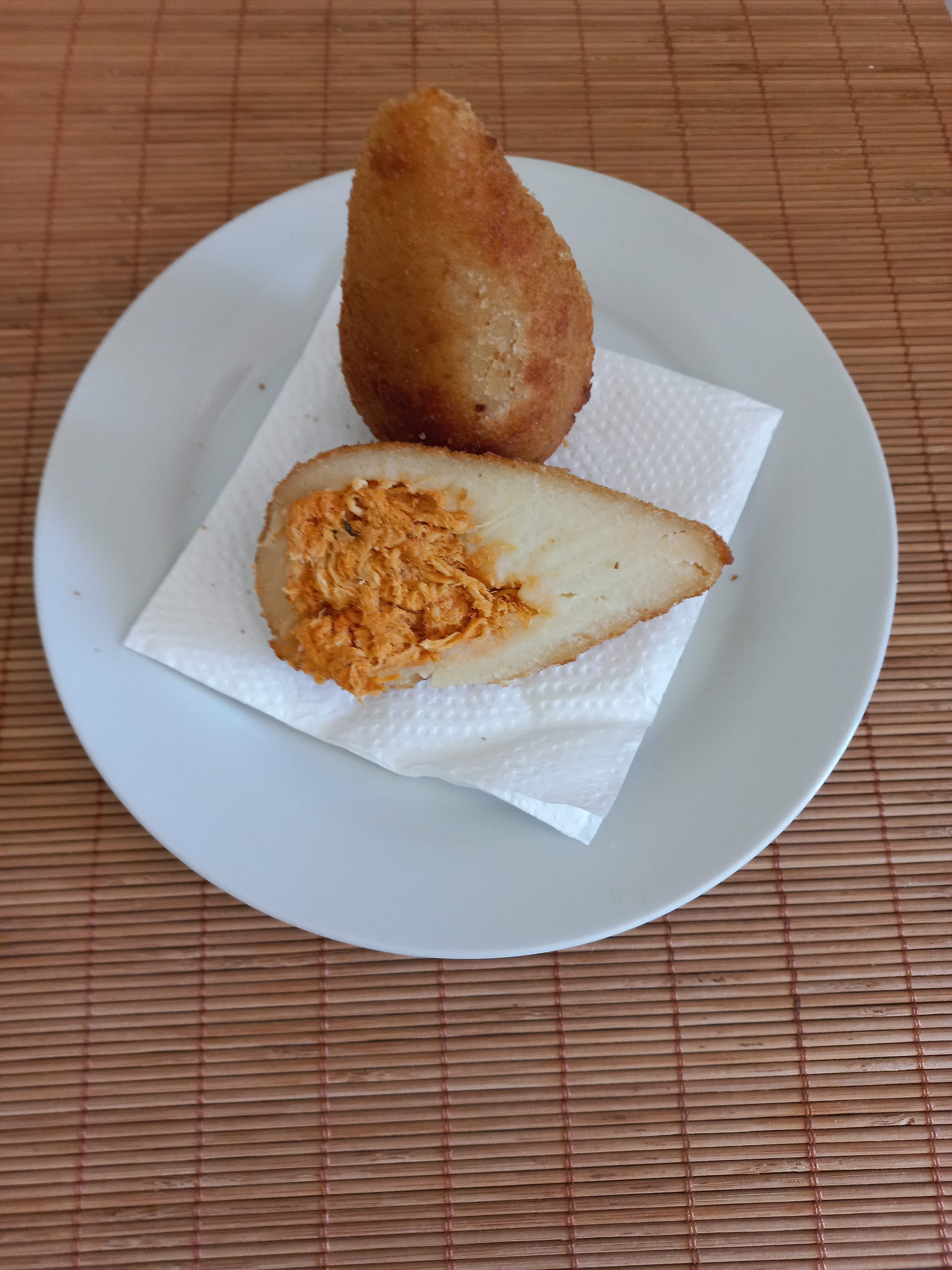 A single teardrop-shaped, breaded, deep-fried snack