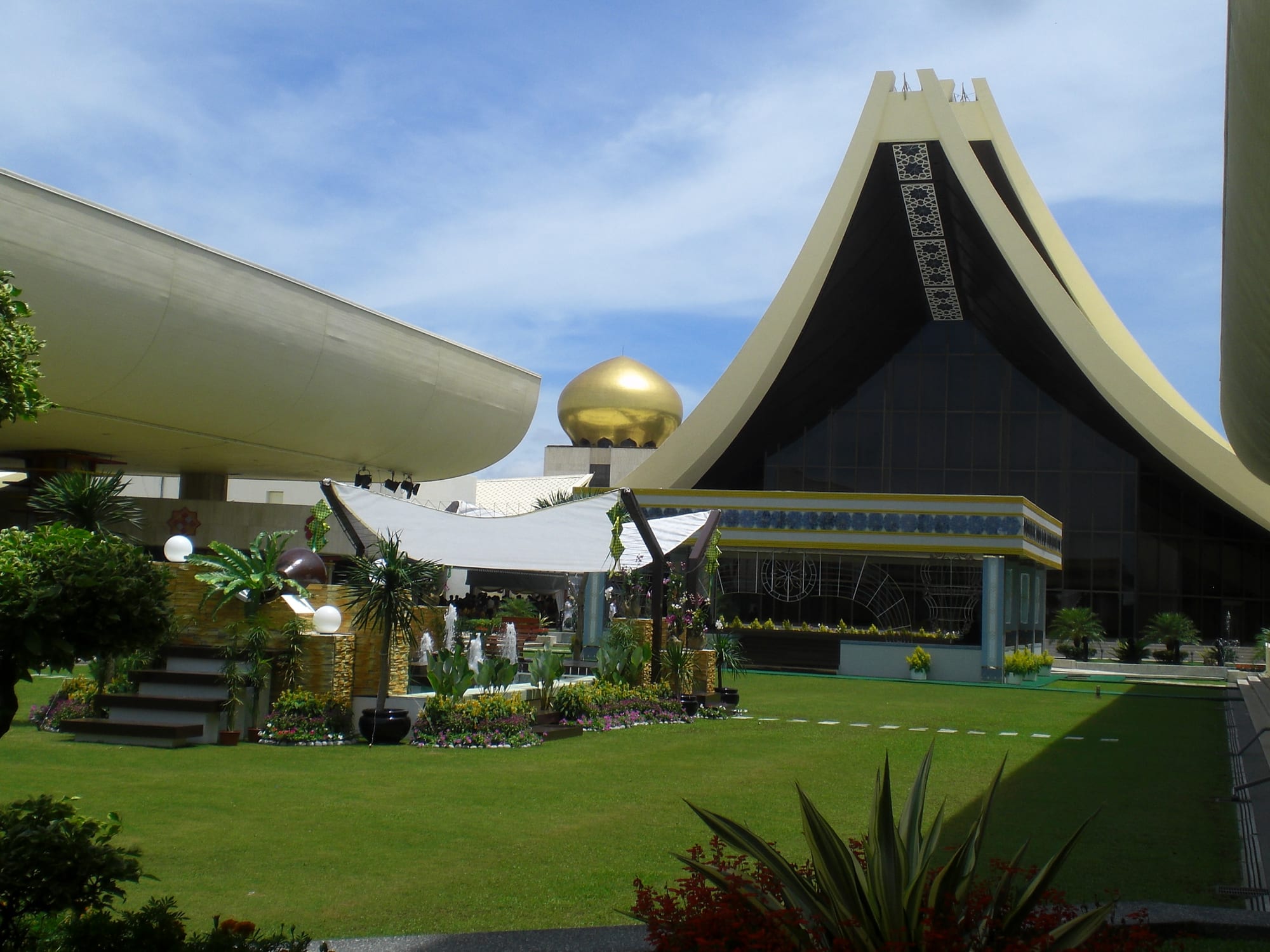 An immense palace complex with golden domes and sweeping roofs on a hill above a river