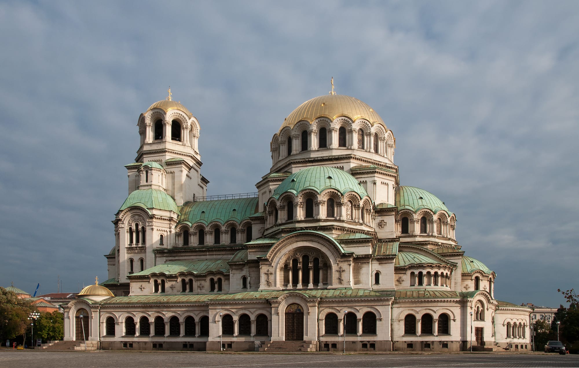 A massive cathedral topped by a cluster of green and gold domes