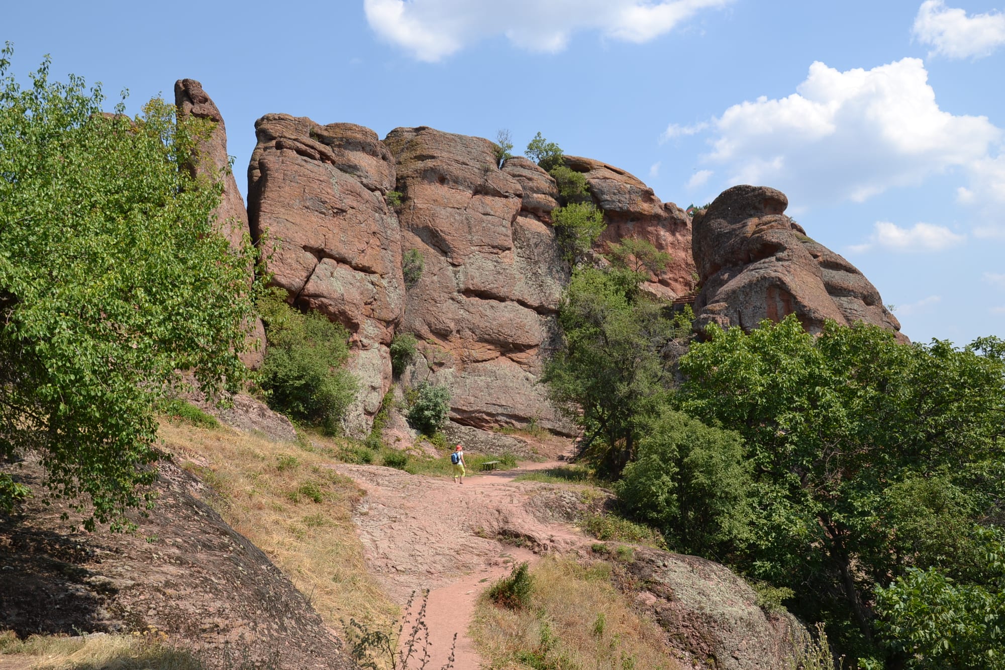 Towering red-brown sandstone pillars and outcrops rising from forested hills