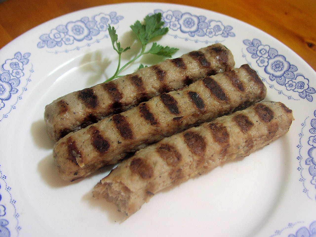 Two grilled logs of minced meat on a plate
