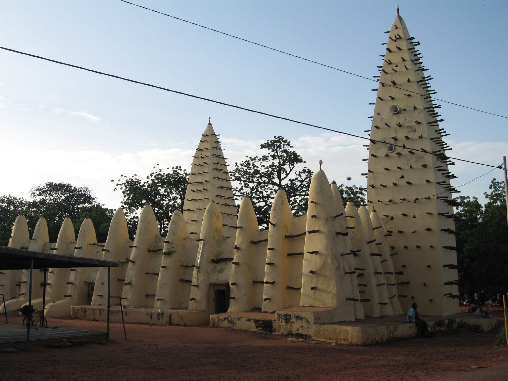 A mud mosque with conical buttressed towers bristling with projecting wooden beams