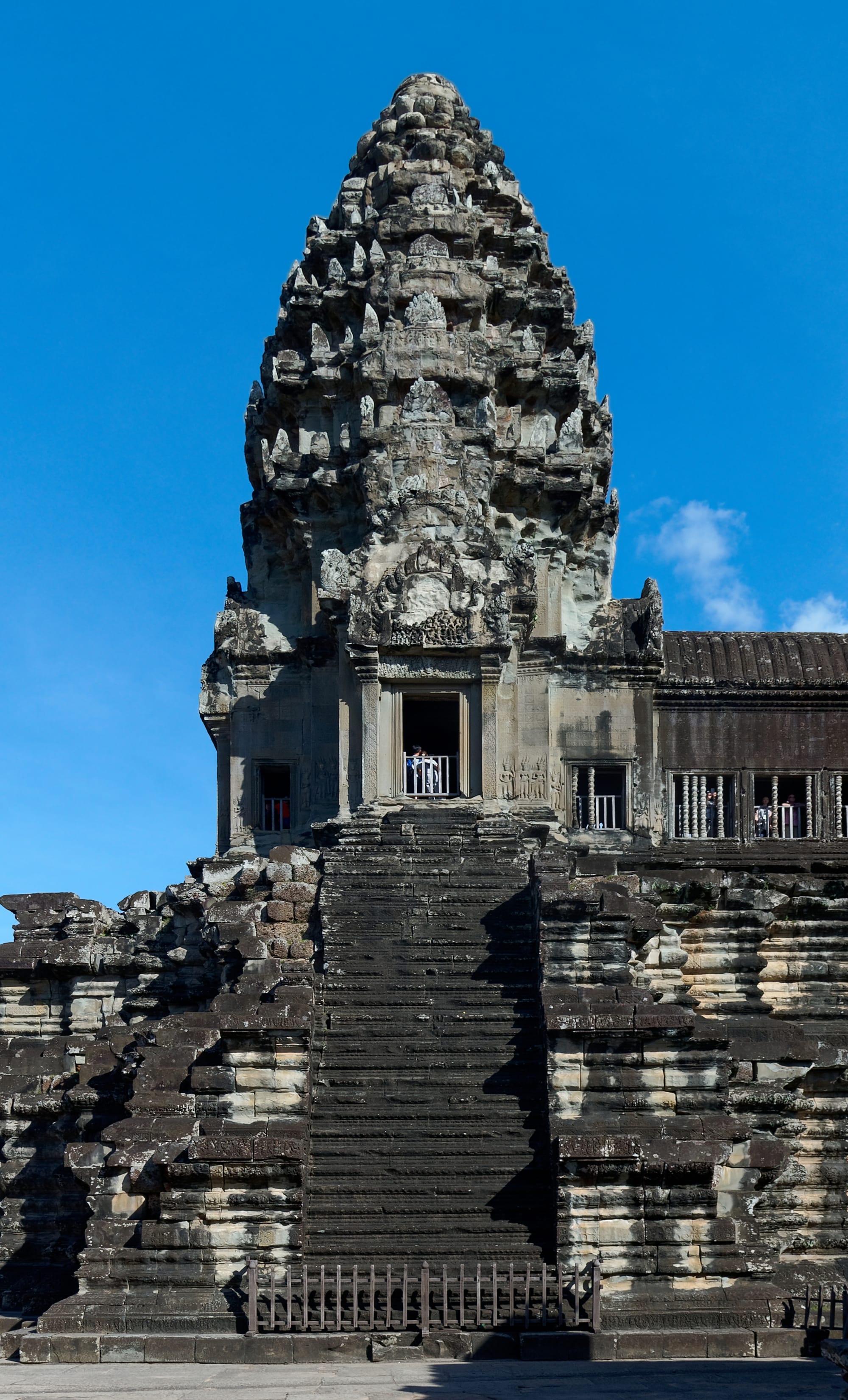 A grand stone temple with corncob-shaped towers under a bright blue sky