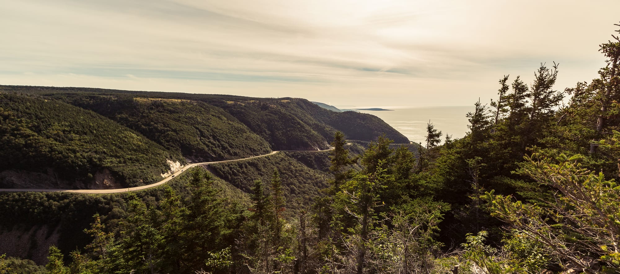 A coastal highway curving along steep green headlands above the Atlantic
