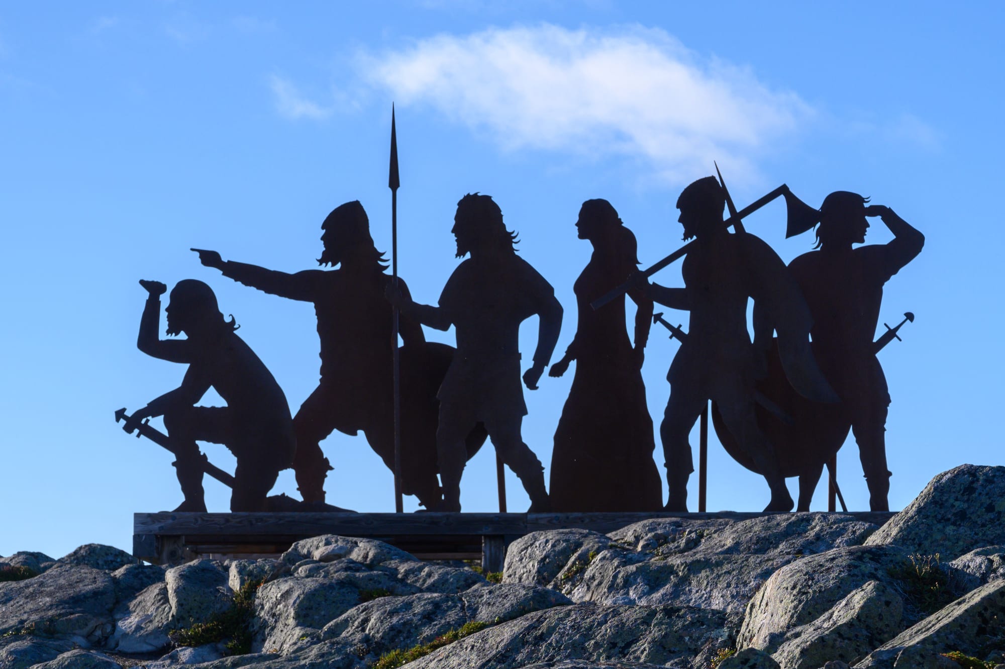 Life-size metal silhouette sculptures of Norse figures on a windswept coastal headland