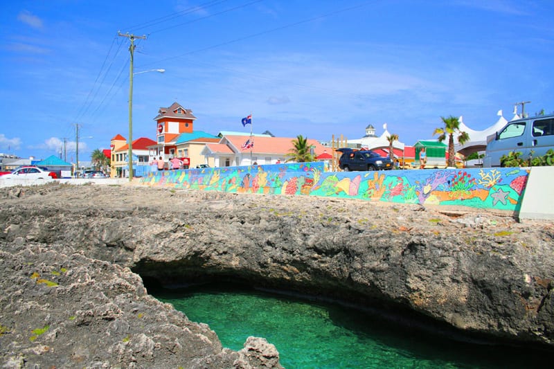 A low waterfront town of pastel buildings along a harbour
