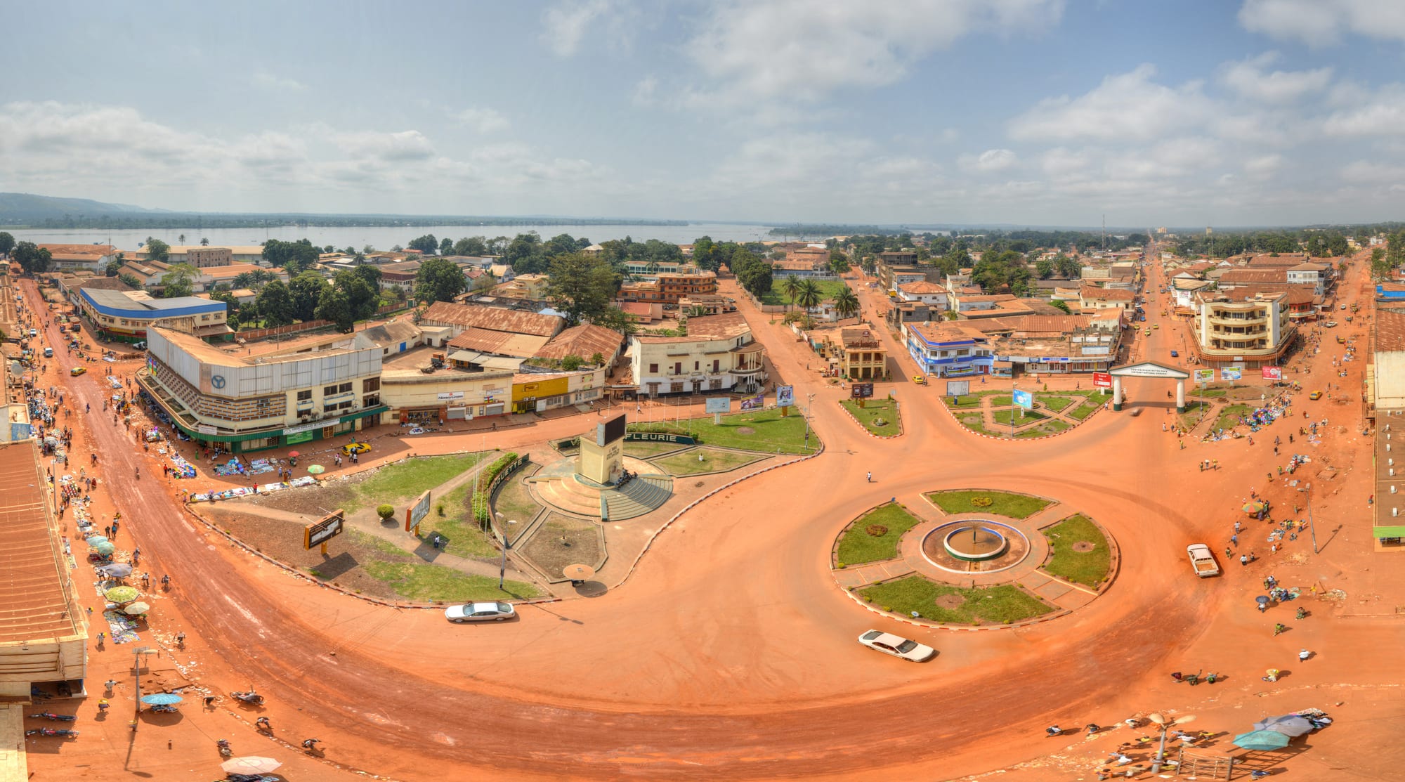 A low-rise African city centre with wide streets and green hills behind