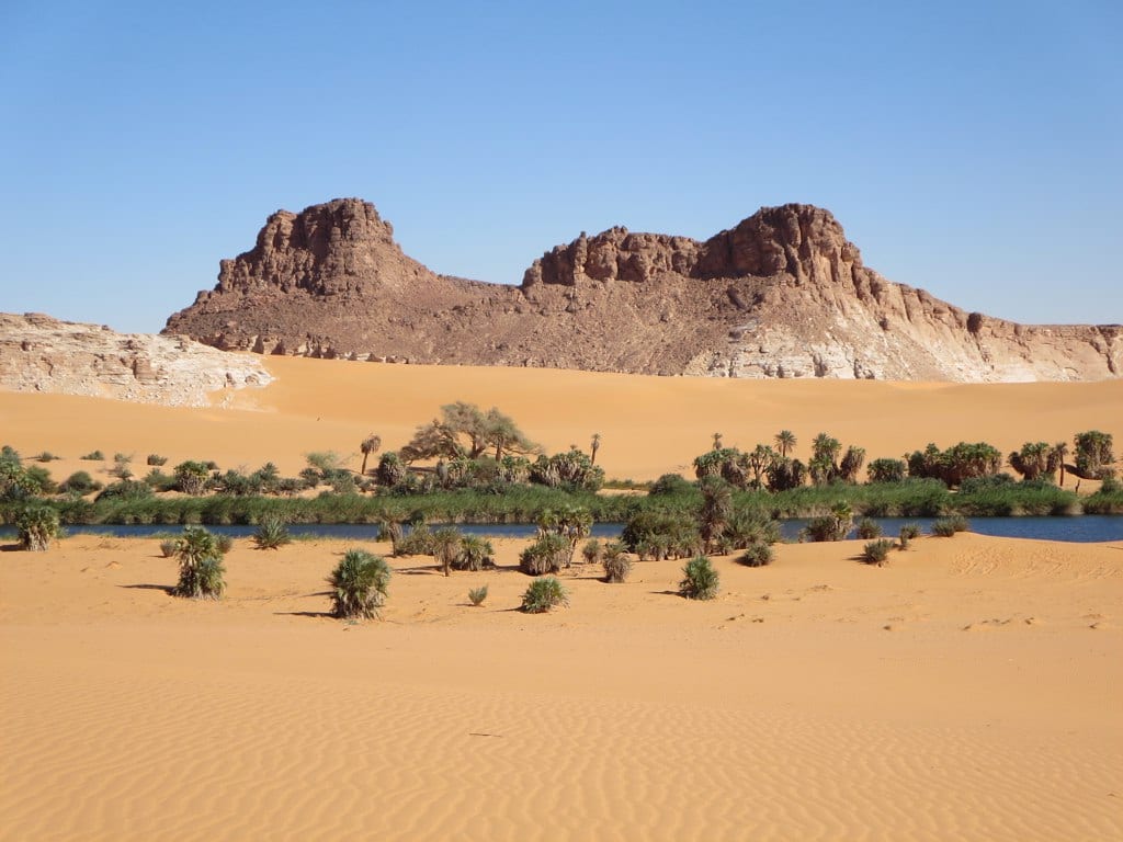Vivid blue and green lakes fringed with reeds and palms, set among orange sand dunes