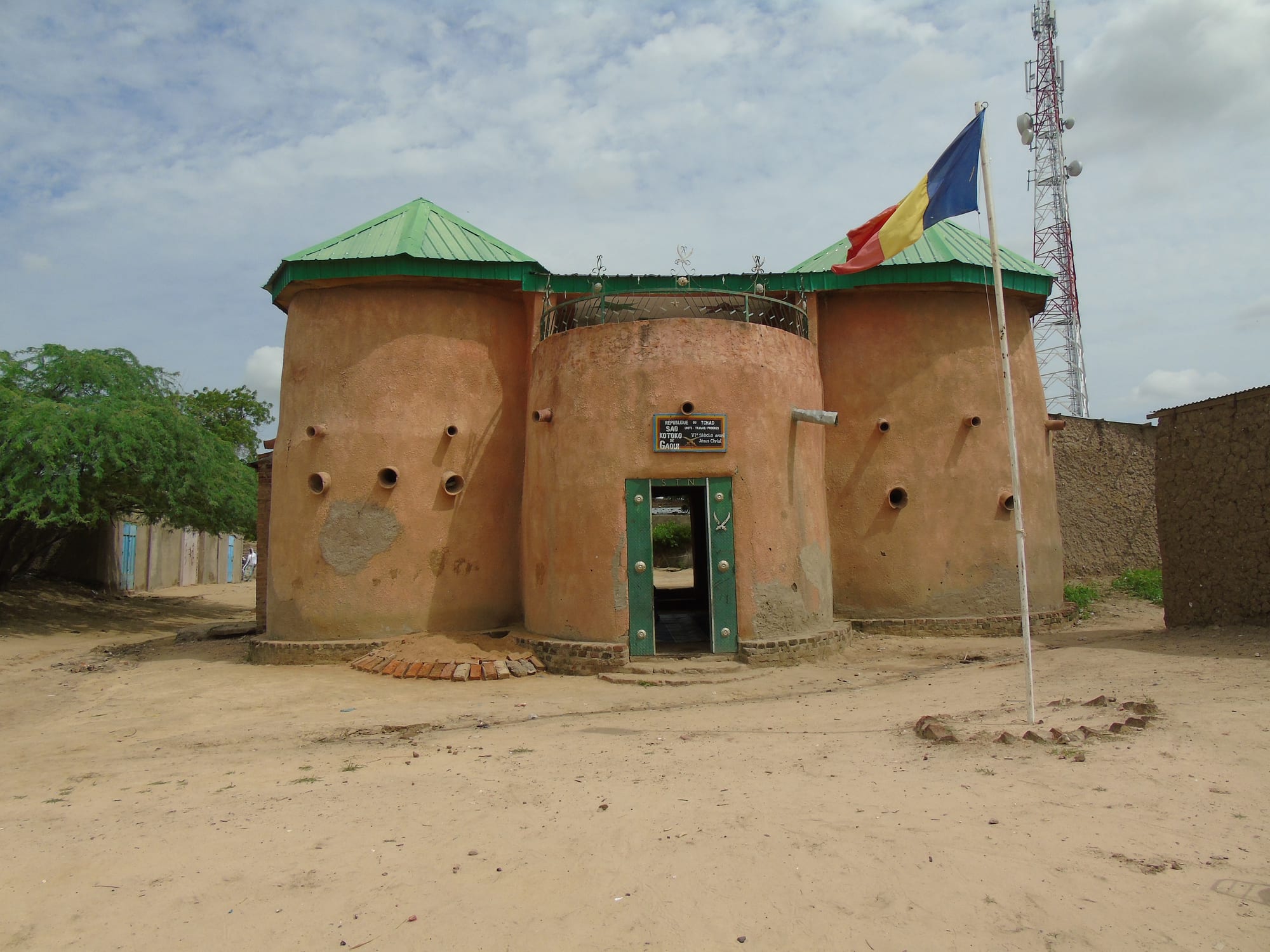 A mud-brick house with geometric painted and moulded decoration around the doorway