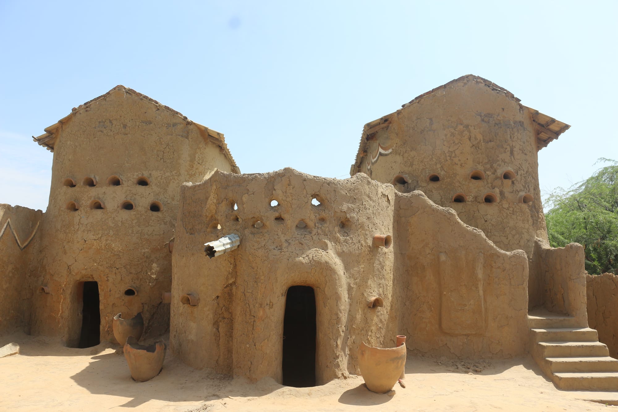 Two adjoining traditional mud-brick towers with sculpted, pockmarked walls and small round openings, in Gaoui near N'Djamena